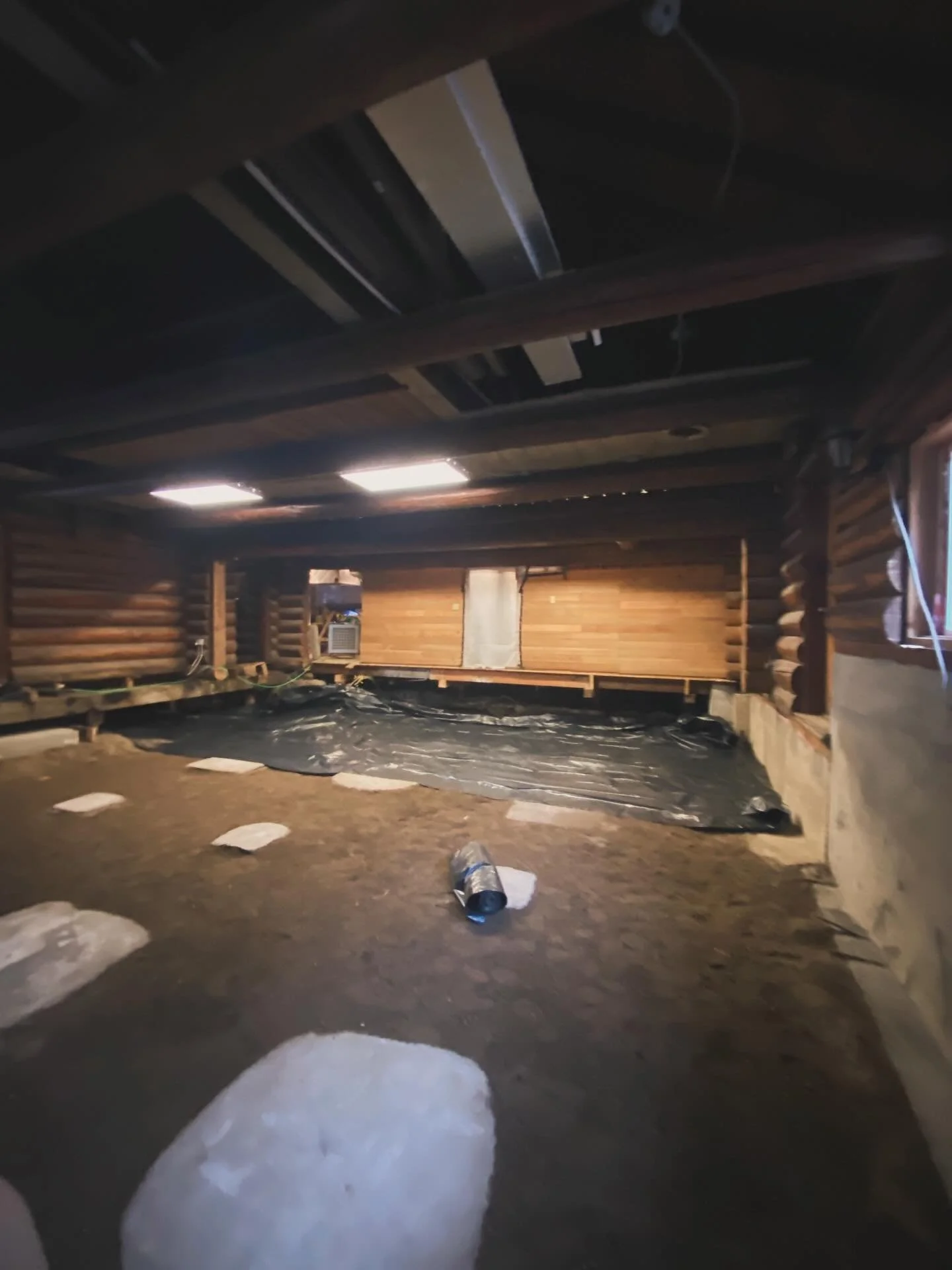 Finally after all of the earth was removed, the footings set, and the materials in place, it was time to roll out the plastic for the vapor barrier and get the post and beam in place. Our carpenter buddy David got to work squaring then building up th