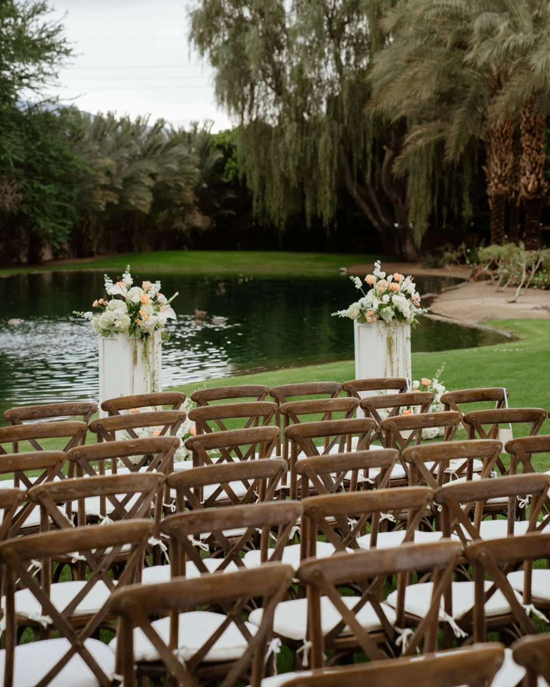 Overcast skies? No problem. White and orange florals brought brightness and energy to every corner of this ceremony!⁣
⁣
Photo: @chasinglight.tv⁣
Florals: @lc__co