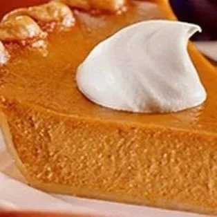Slice of pumpkin pie topped with whipped cream