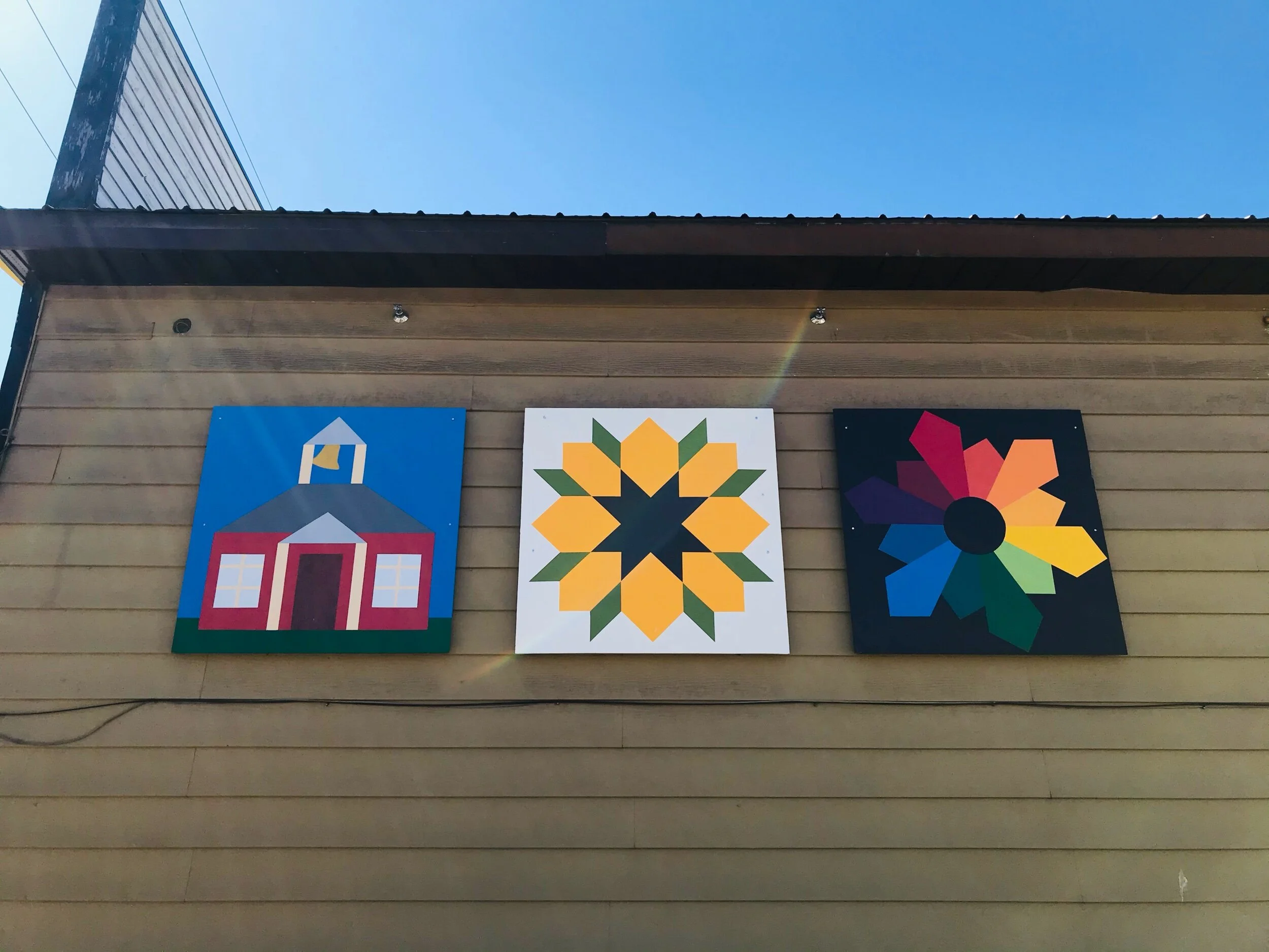 The Barn Quilt Trails “ School House, Swoon Block Sunflower and Dresden Plate Variation” are displayed on the Armstrong Spallumcheen Museum and Art Gallery. Shuswap Adventure Girl
