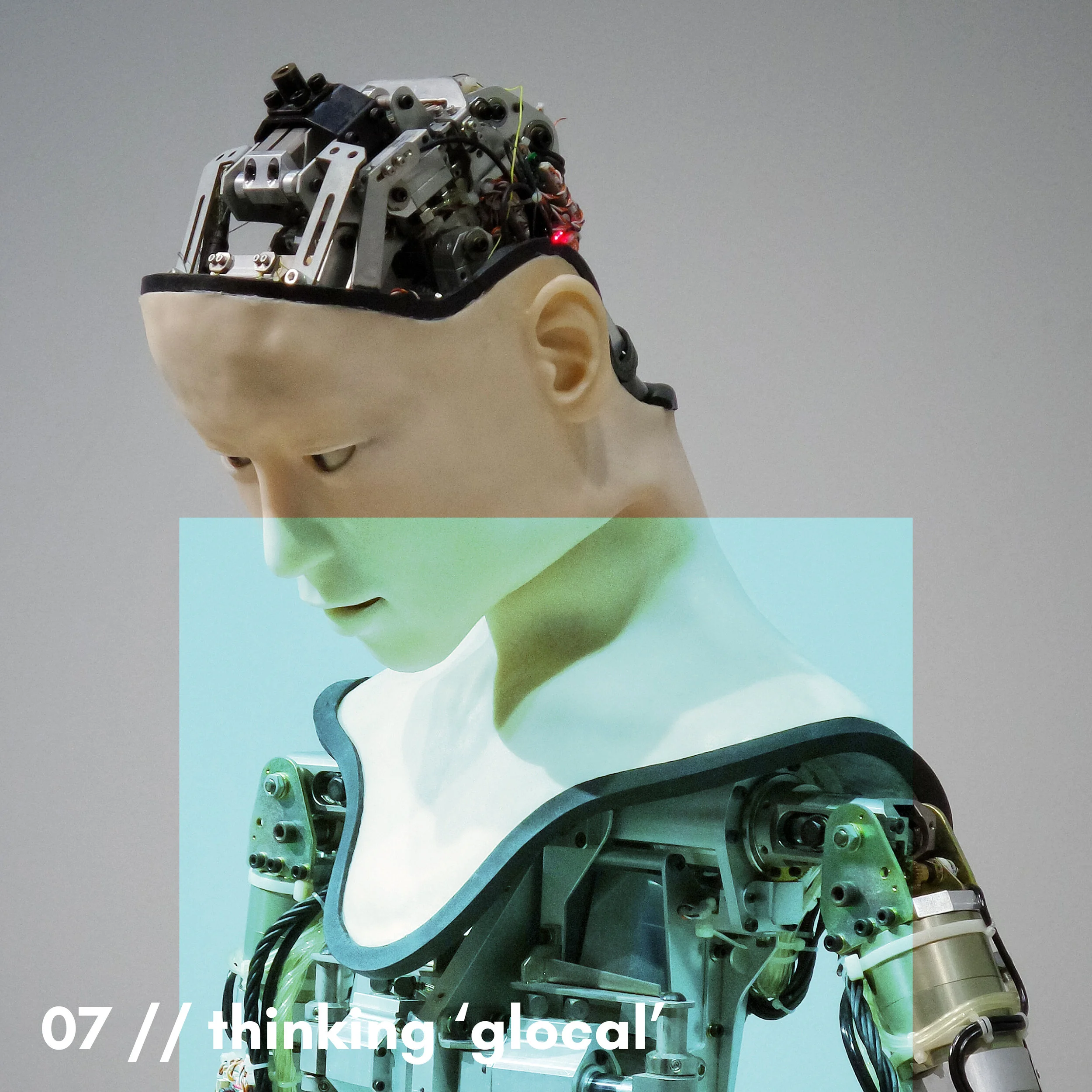 Close-up of a robotic head with electronic and mechanical components, mounted on a mannequin or model head against a neutral background.