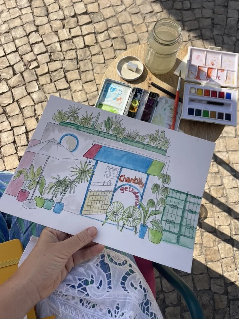 Dibujo a mano de un local llamado 'Chantilly Gelateria', rodeado de plantas en macetas, con una sombrilla y un muro de ladrillos como fondo.