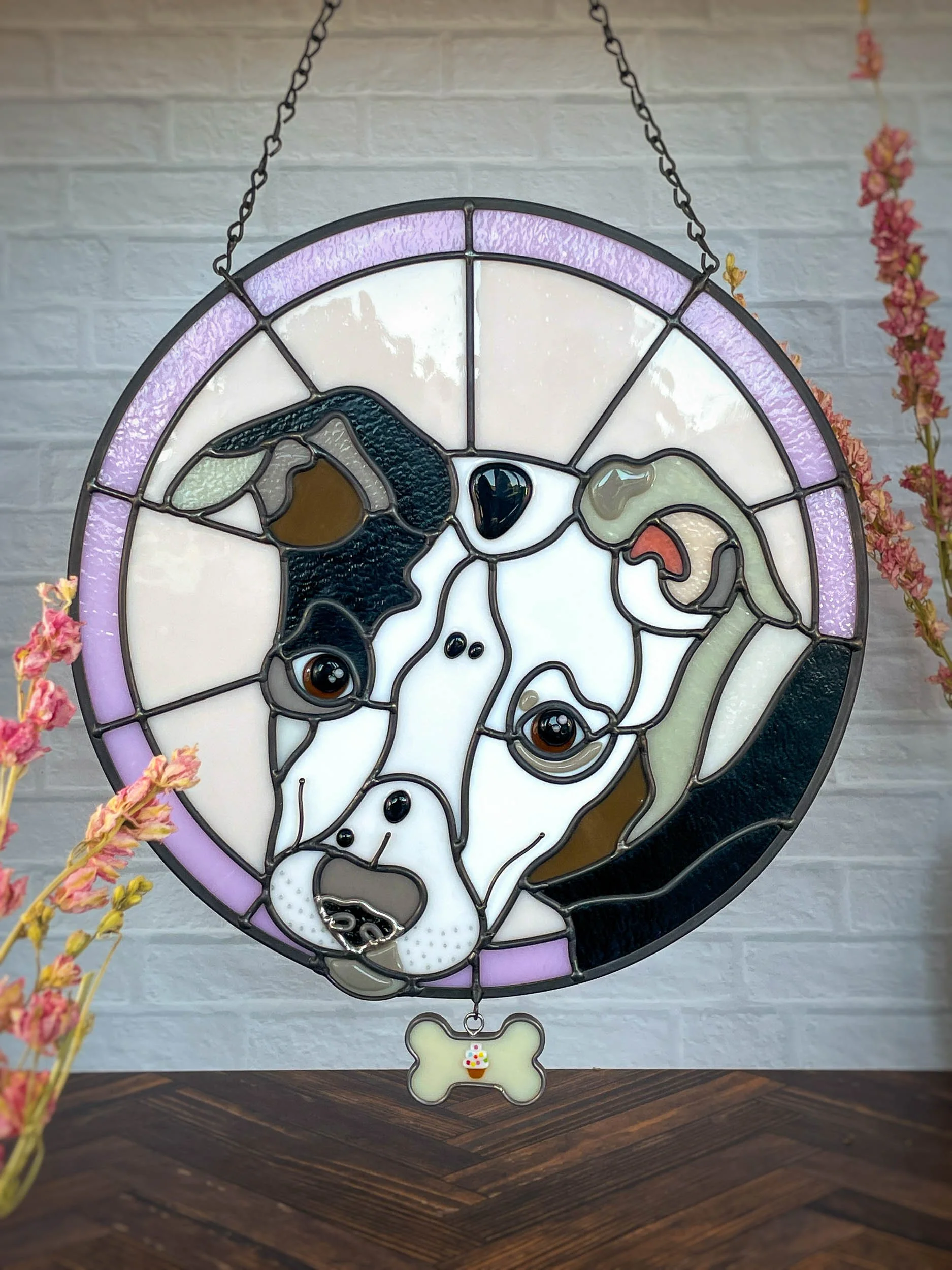 A stained glass pet portrait of a dog surrounded by a pink background