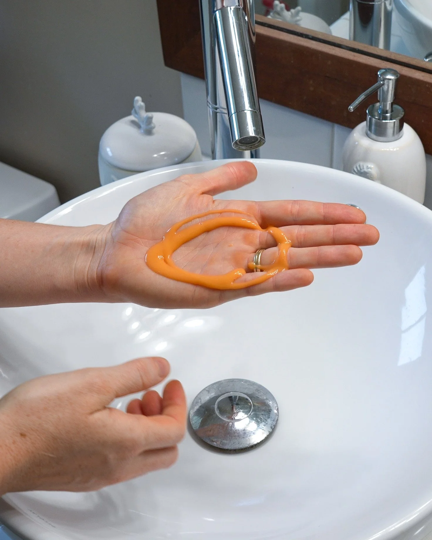 De-leading hand soap covering hands held over a sink