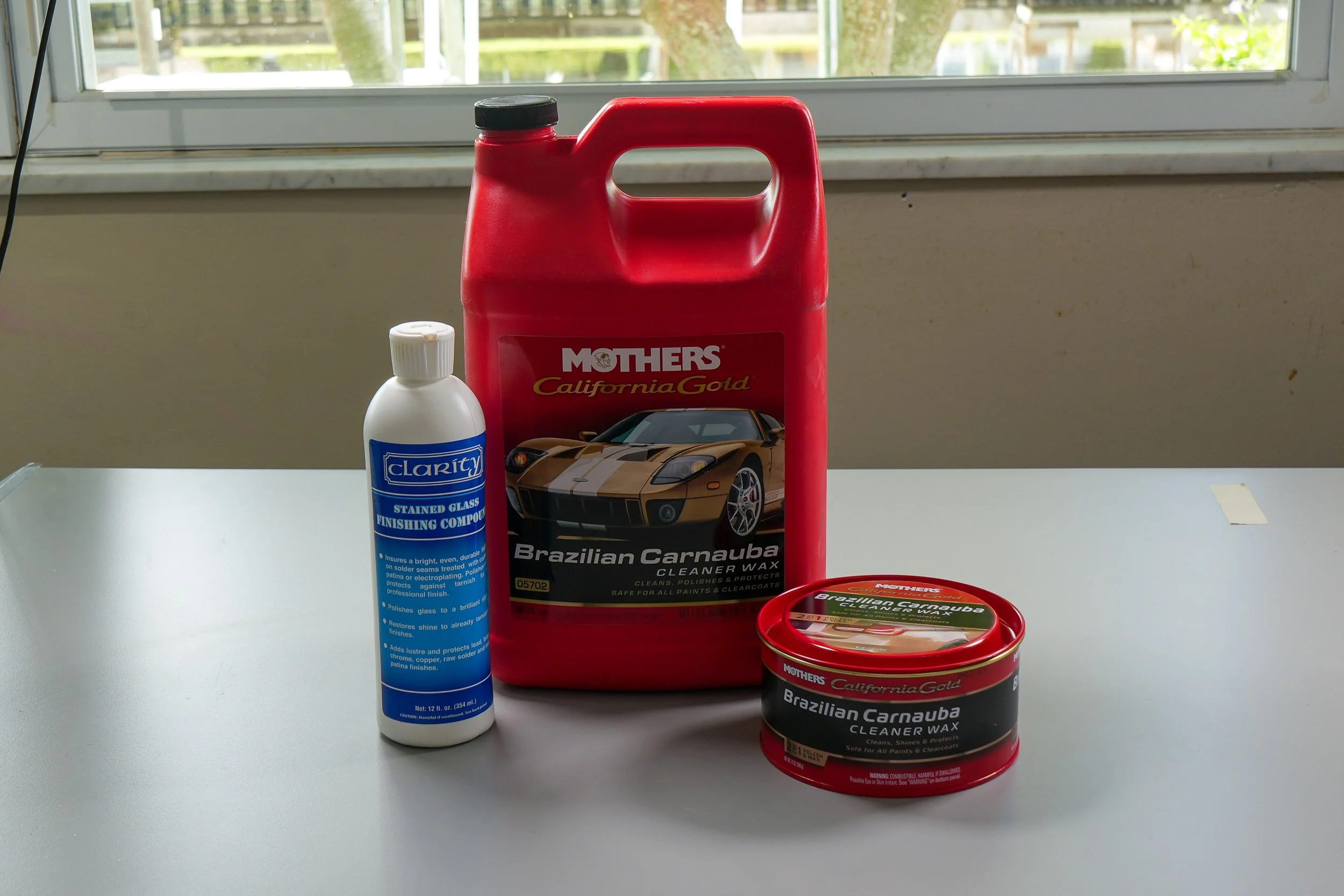 Containers of various types of finishing compounds, waxes, and polishes for stained glass