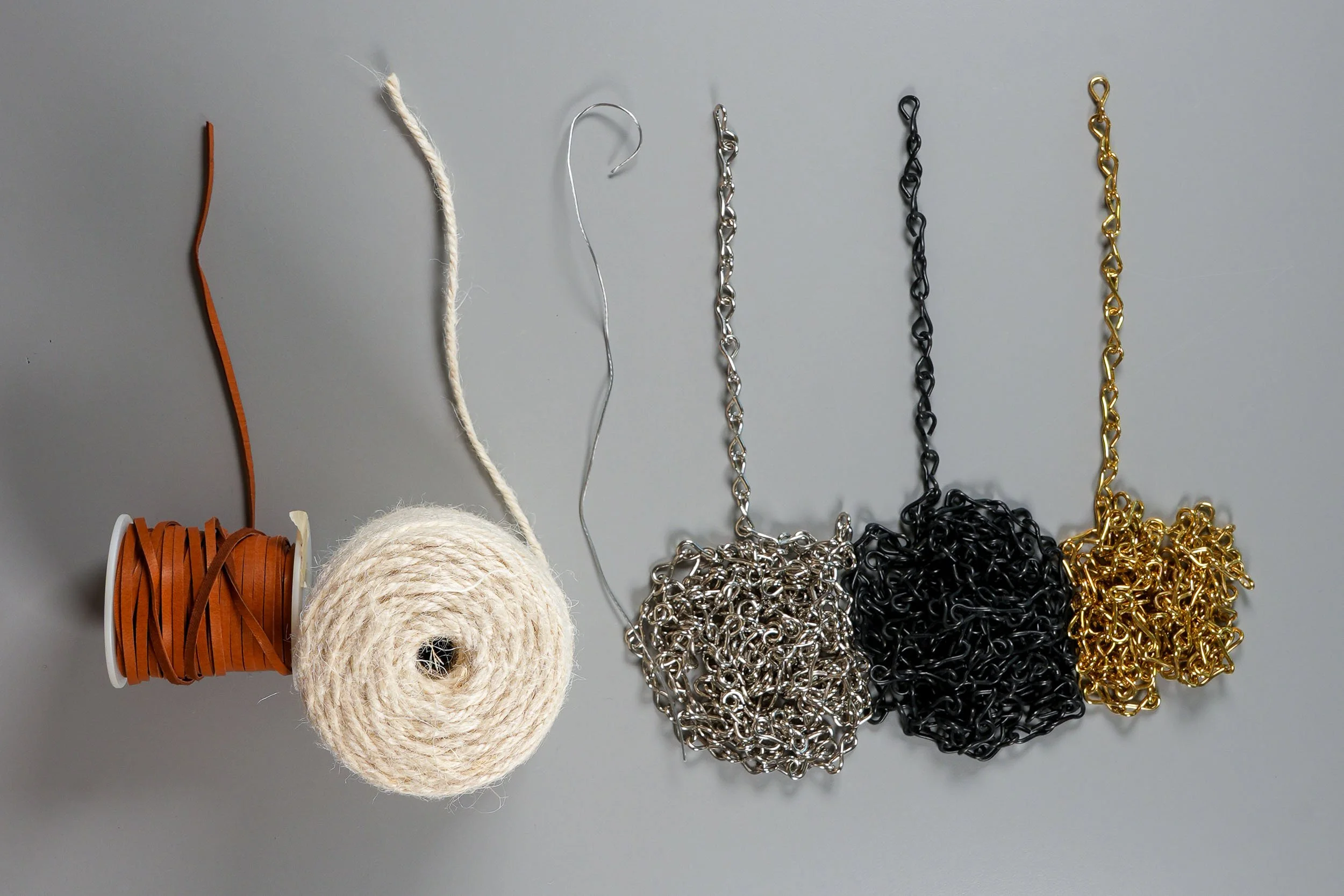 Spools of leather, twine, and different colored chains