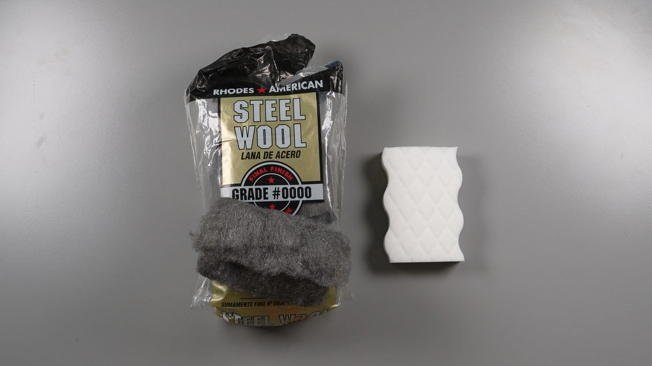 A bag of super-fine steel wool next to an abrasive Magic Eraser scrub pad