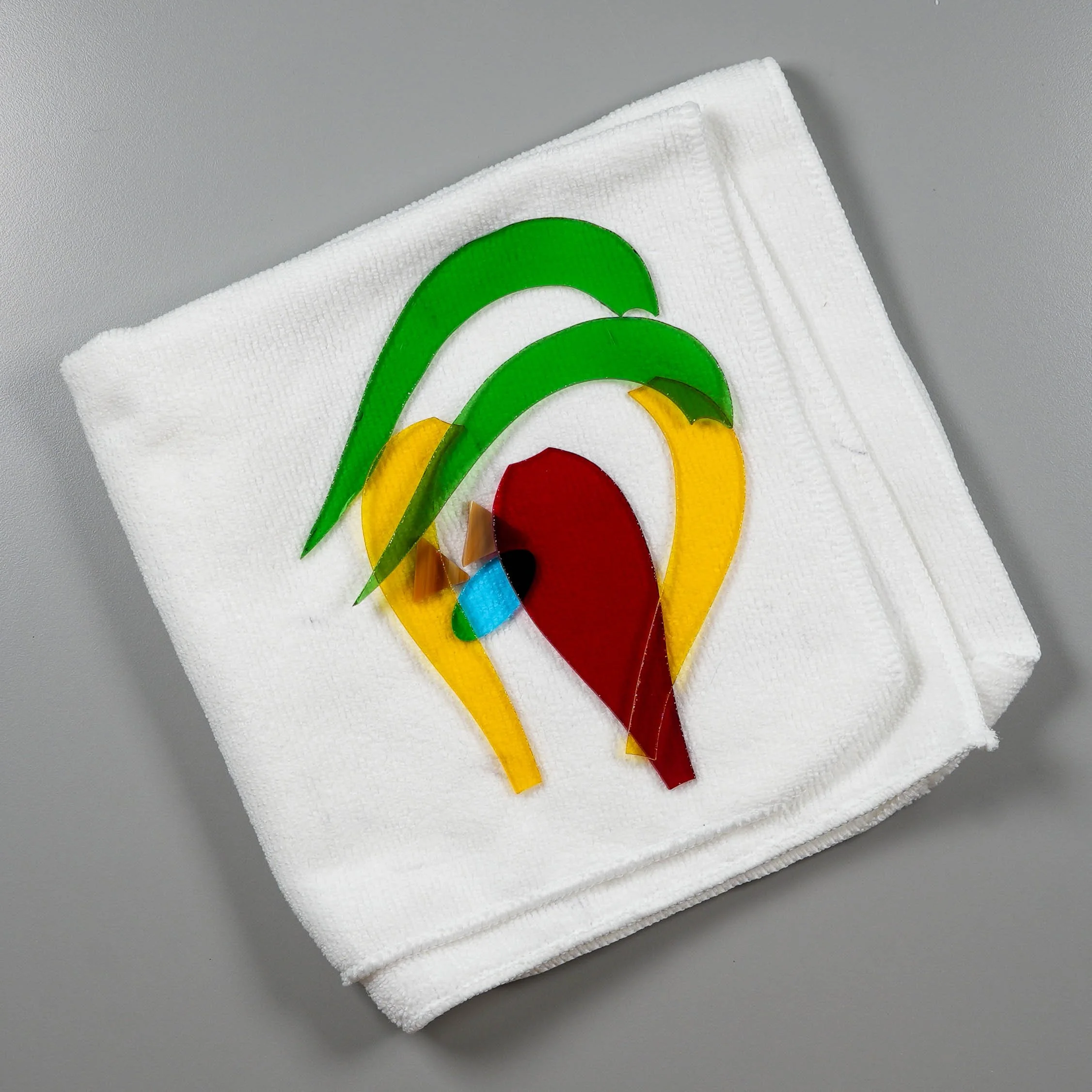 Various-colored shaped pieces of stained glass atop a white cloth