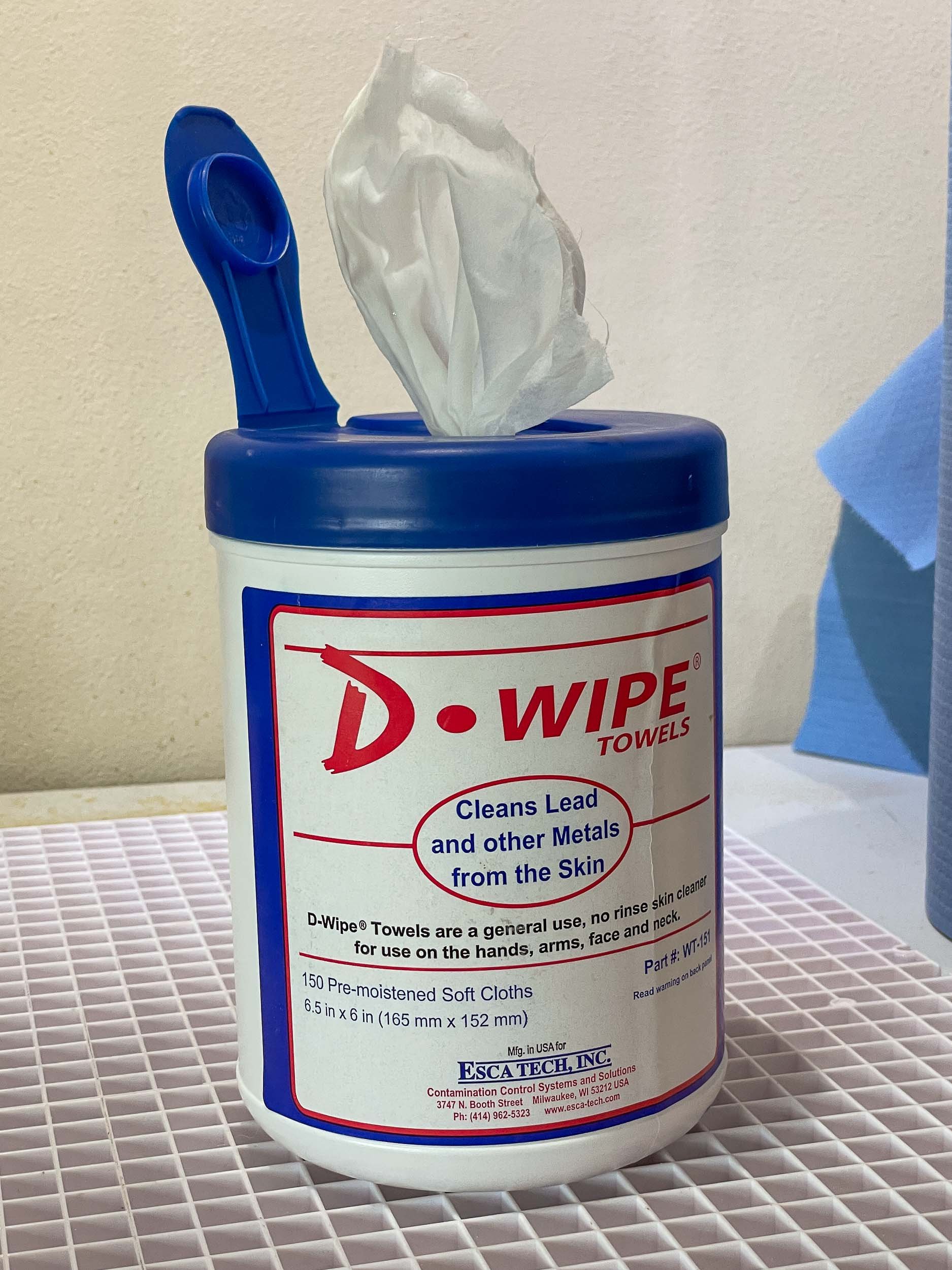 An open container of de-leading surface wipes within a stained glass home studio