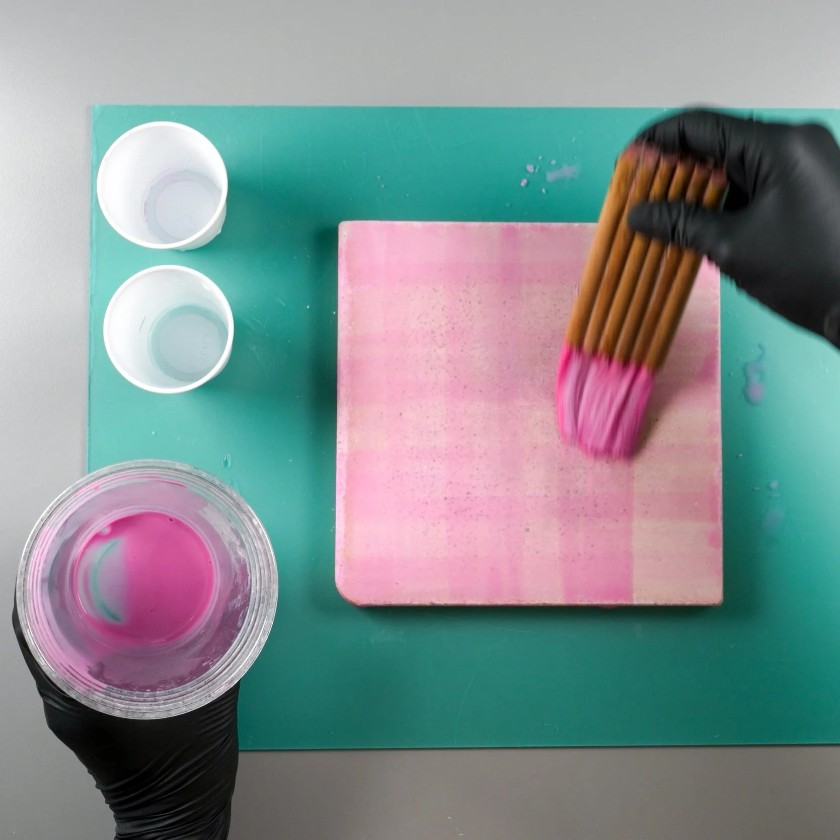 A kiln shelf being primed for firing with kiln wash