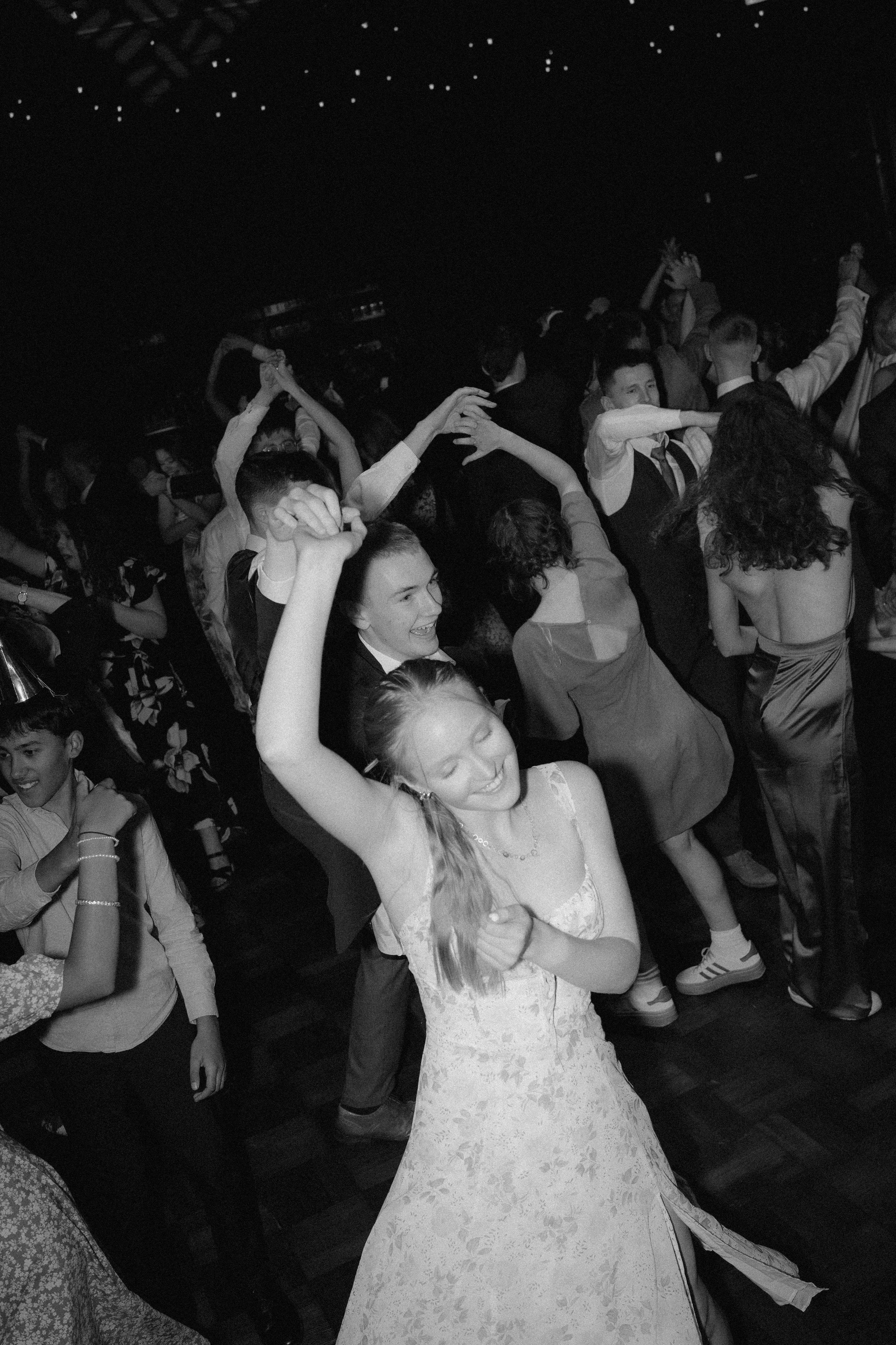 People dancing and having fun at a celebration or party in a dimly lit venue.