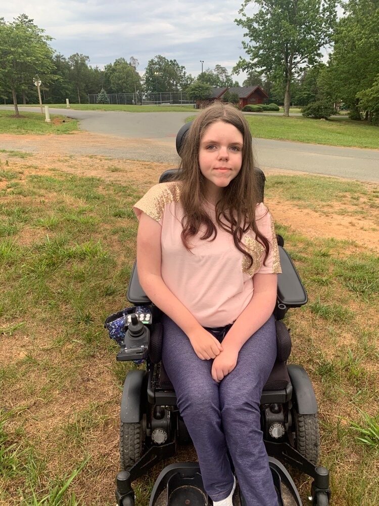 Haley in her wheelchair, on a field