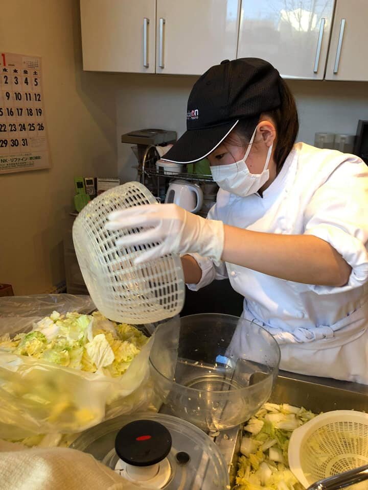 Riho dumping cabbage into a bowl