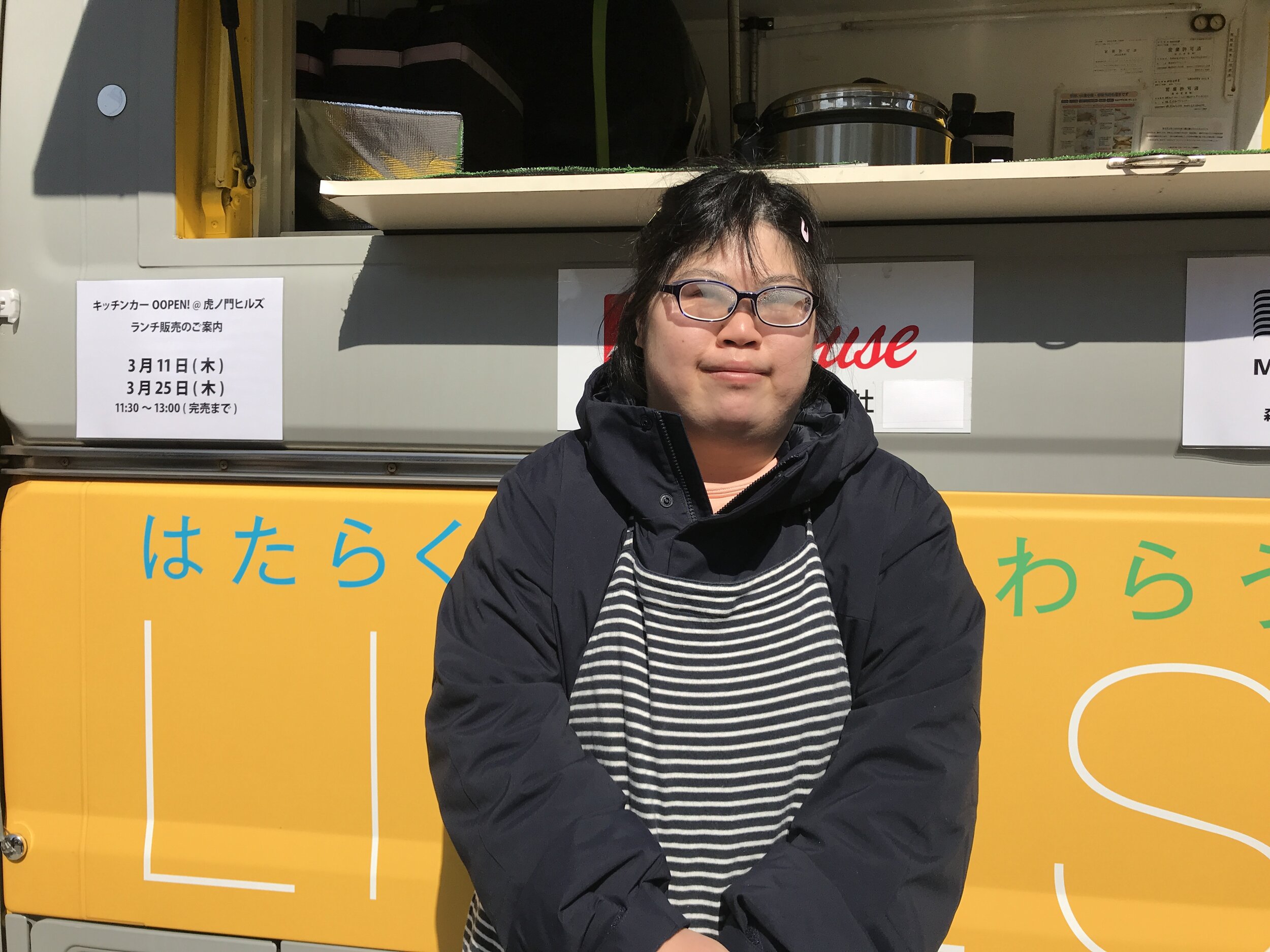 A picture of Haruka standing in front of the LIVES Food Truck