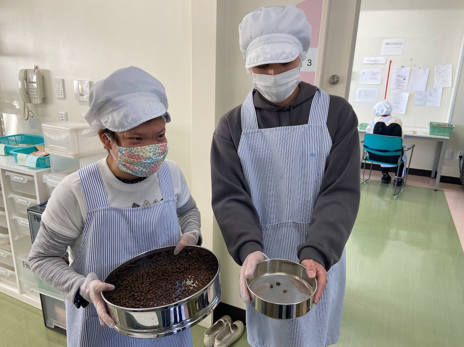  Junko (user) and a volunteer holding a bowl of coffee beans 