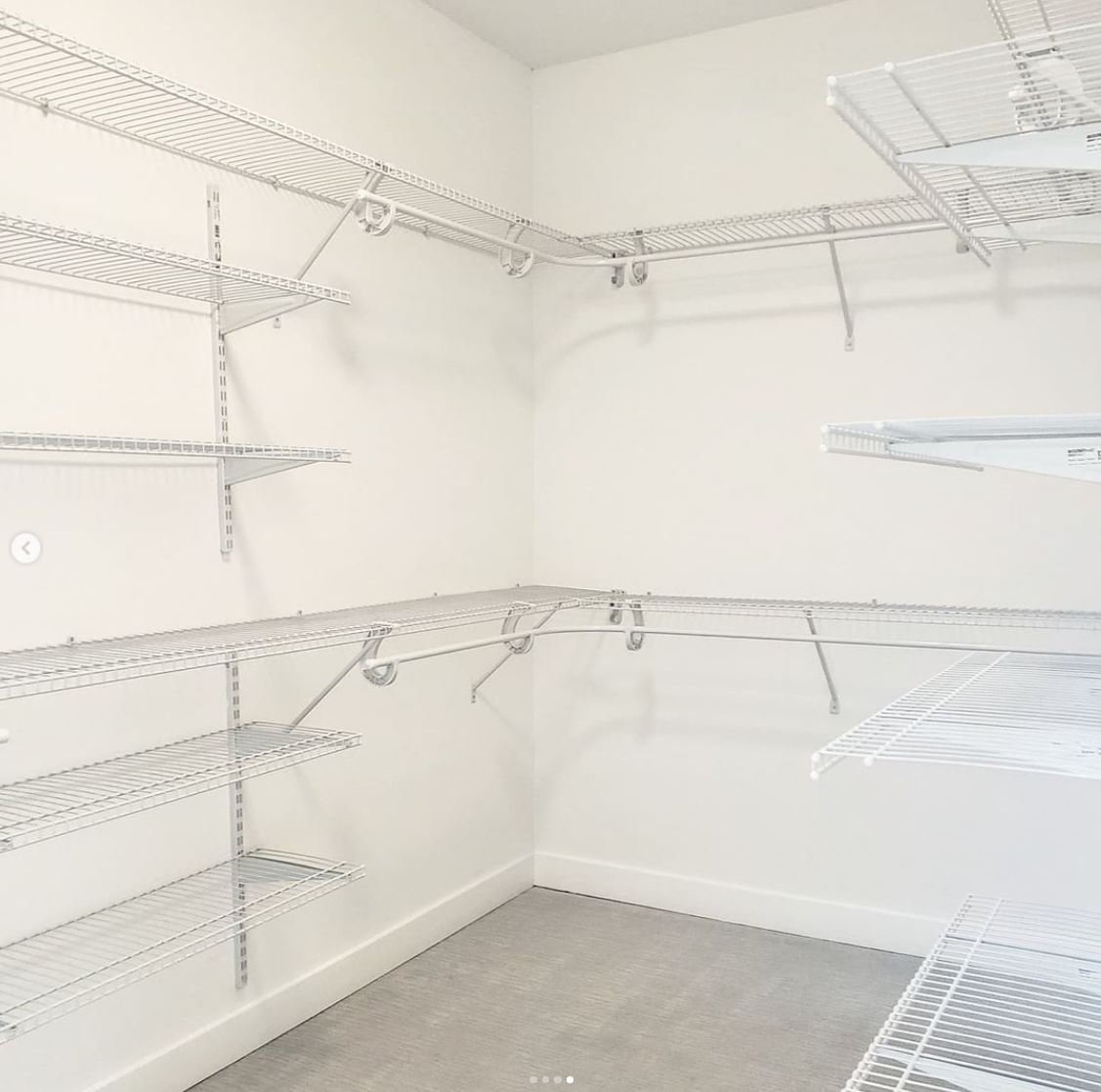 Empty walk-in closet with white wire shelves on white walls