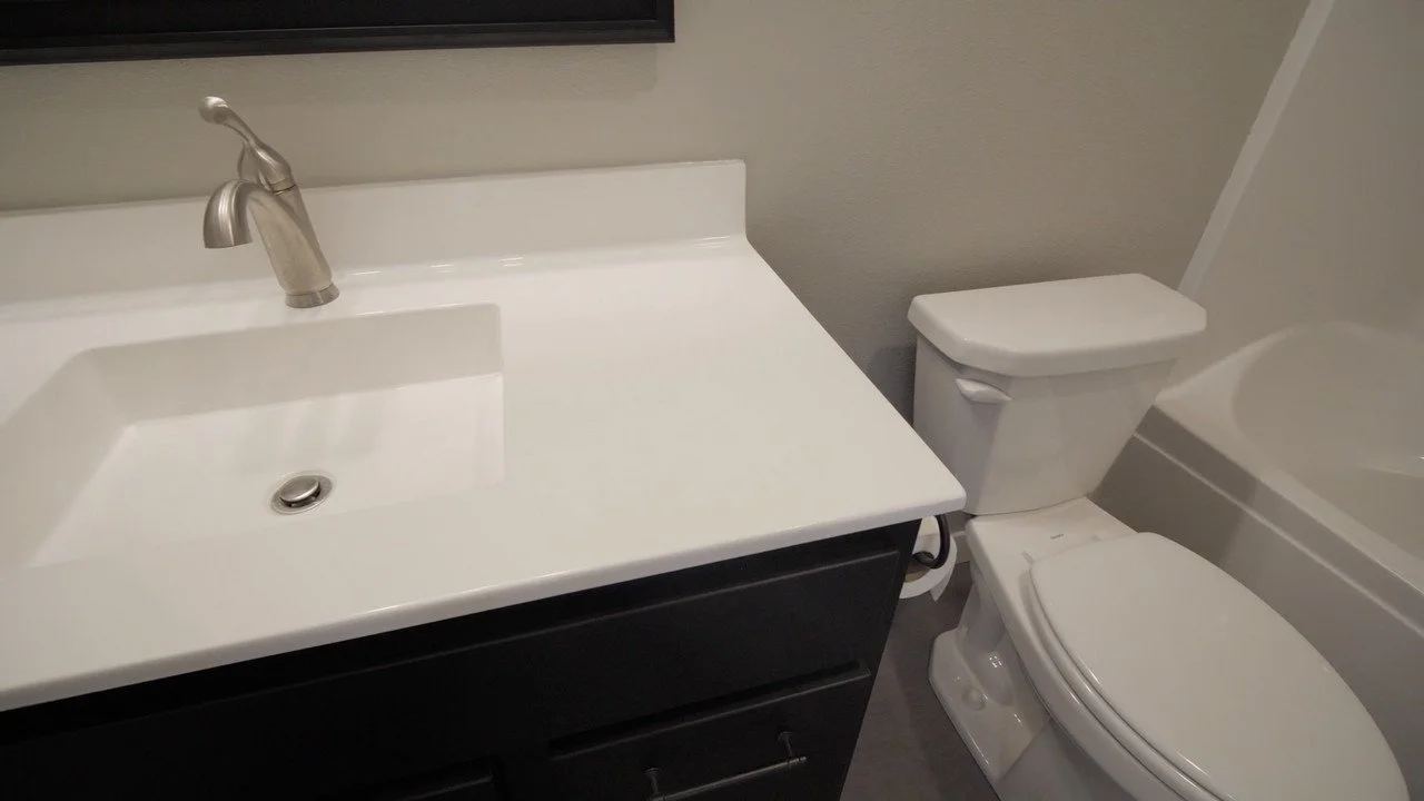 Bathroom with a sink, faucet, toilet, and bathtub.
