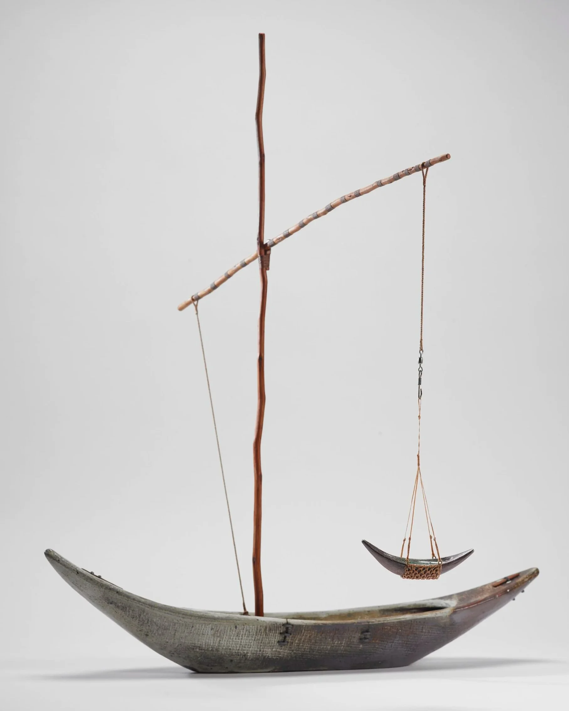 woodfired ceramic vessel with a smaller vessel suspended from a high boom