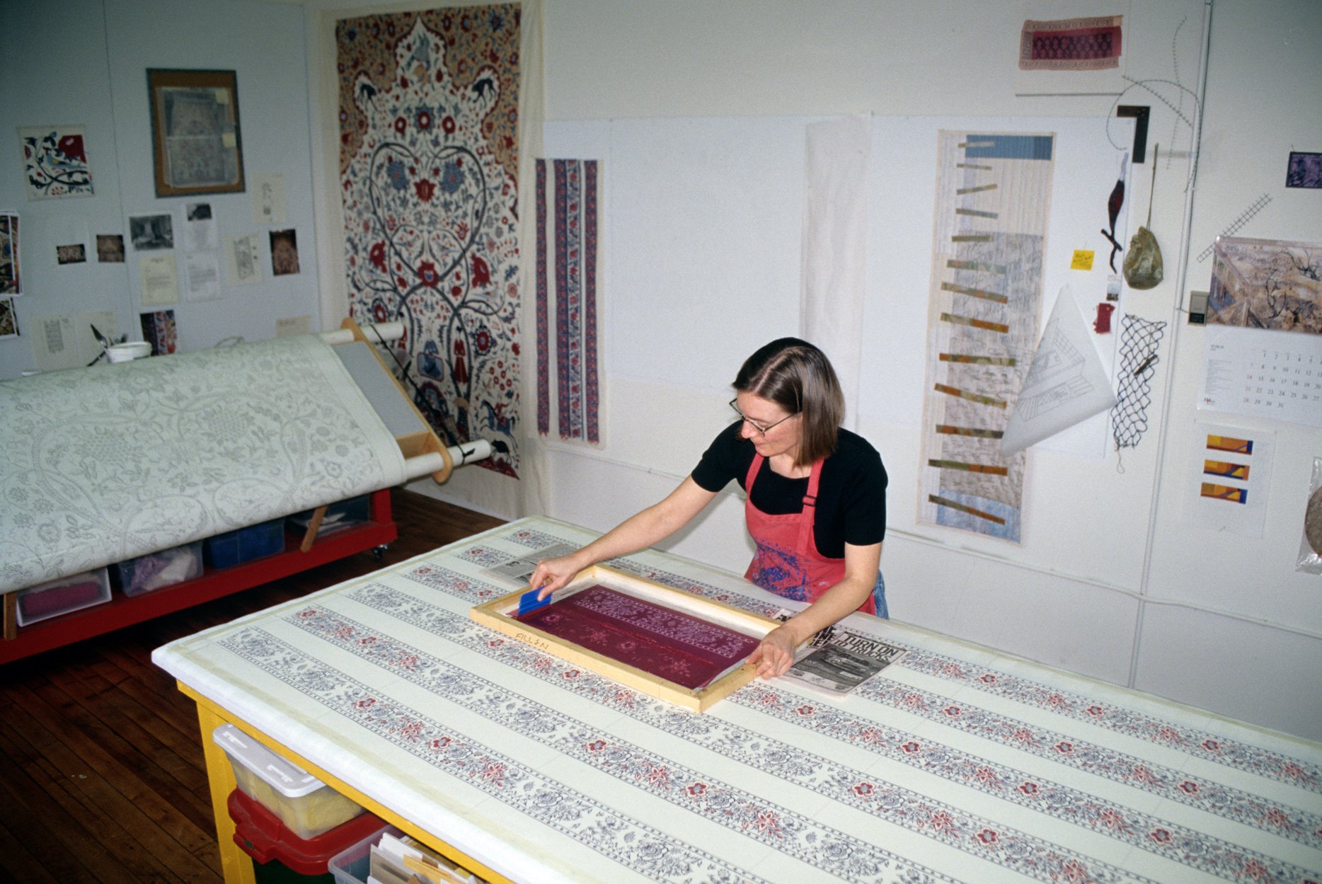 Screen printing the borders. To the left is the cantilevered light table loaded with the working drawing and the first finished panel on the wall.