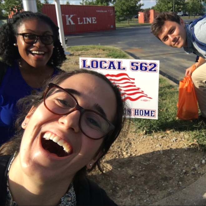  Brittany poses with colleagues in front of a Local 562 union sign. 