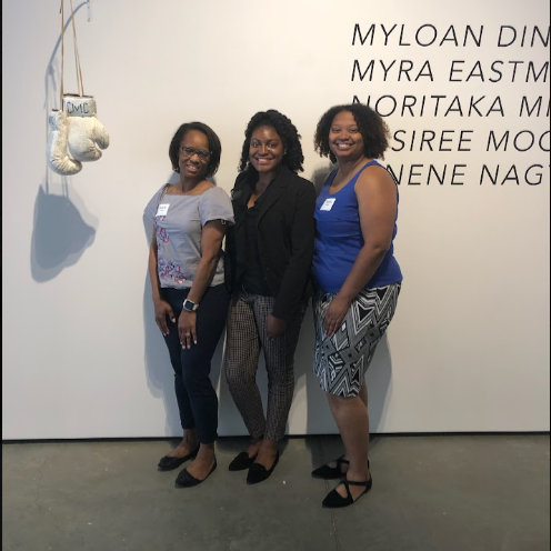  Brittany poses with colleagues in front of a museum installation. 