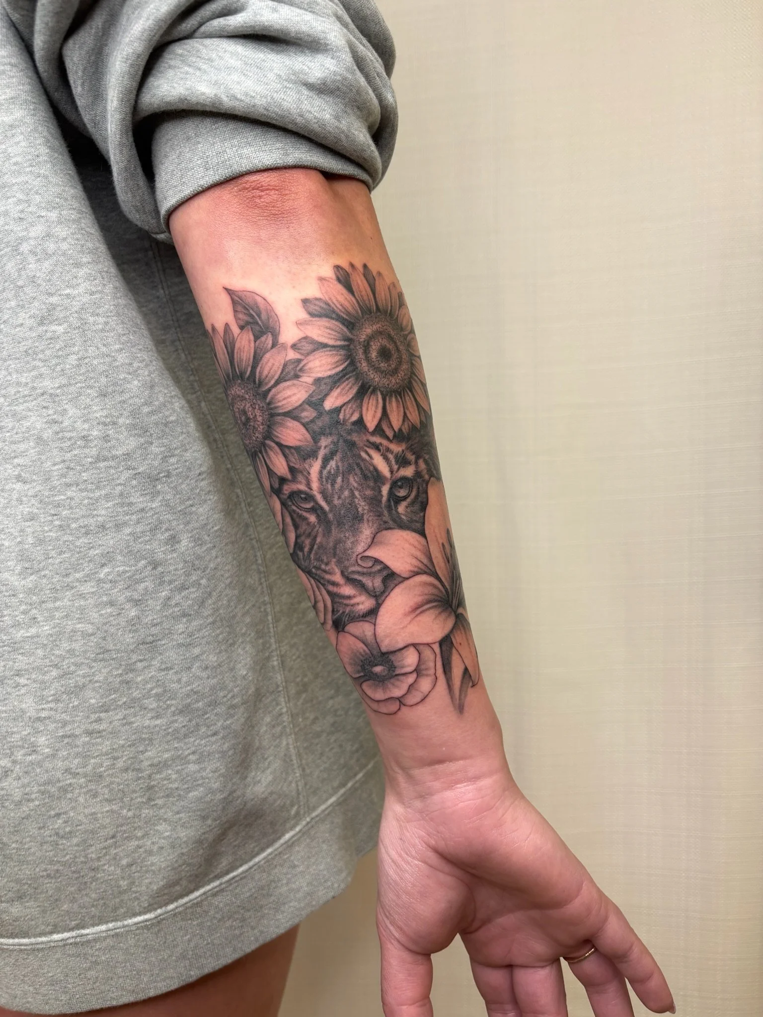A tattoo of a tiger with flowers surrounding it