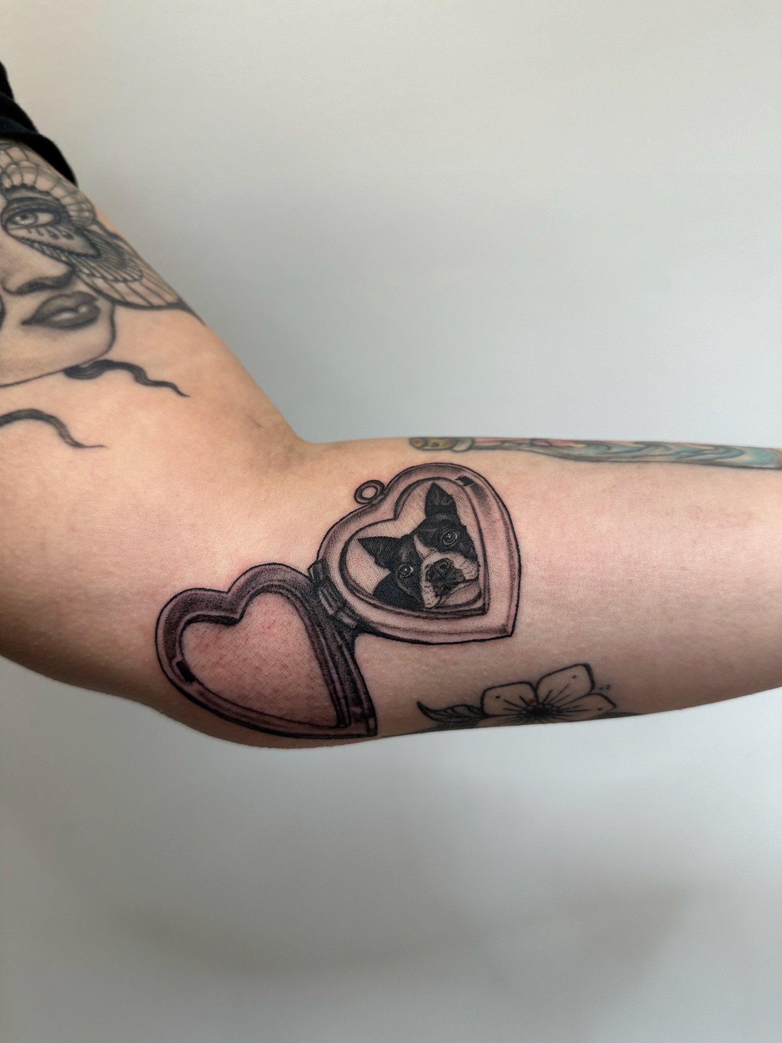 Tattoo of a locket with a dog inside