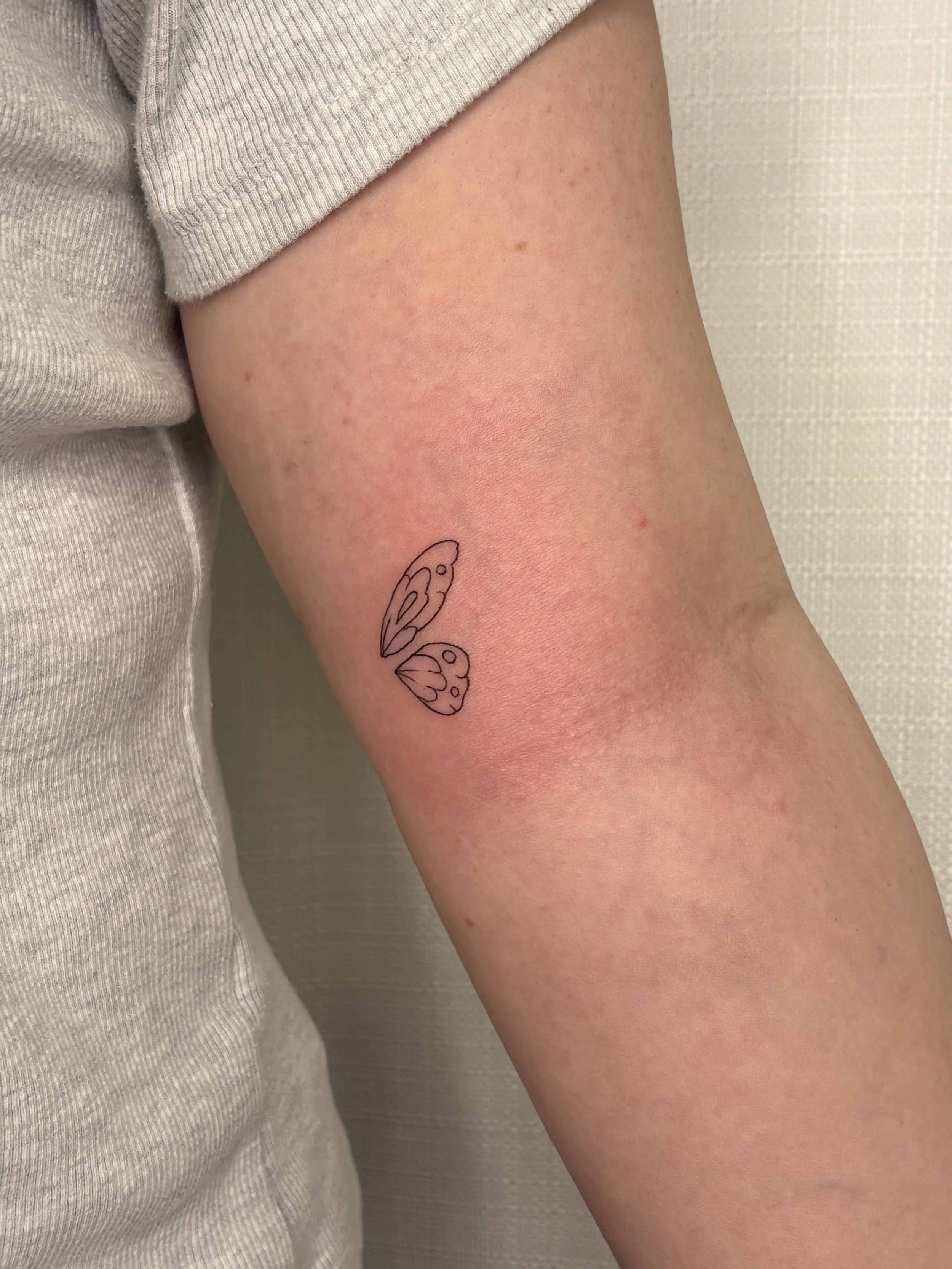 A tattoo of one side of butterfly wings done by Brooke Kalynn