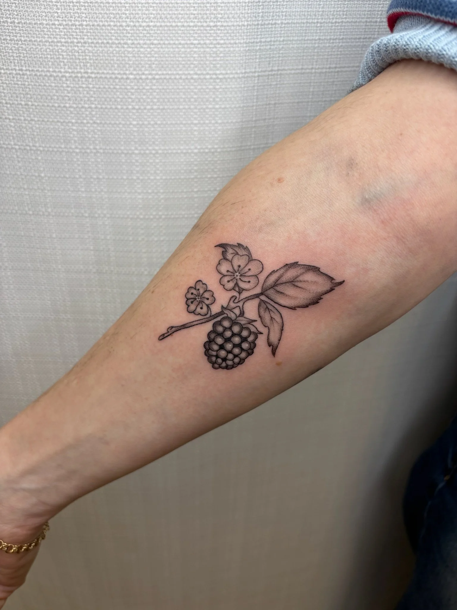 A tattoo of a blackberry and leaves