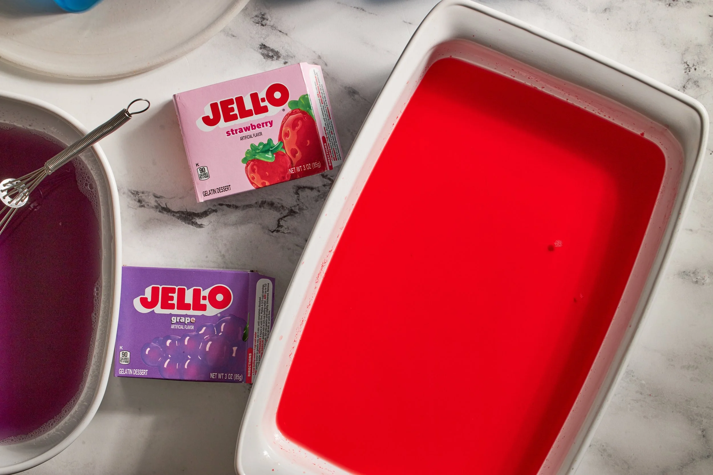 boxes of strawberry jello grape jello blue jello in baking dish for broken jello dessert jessica furniss
