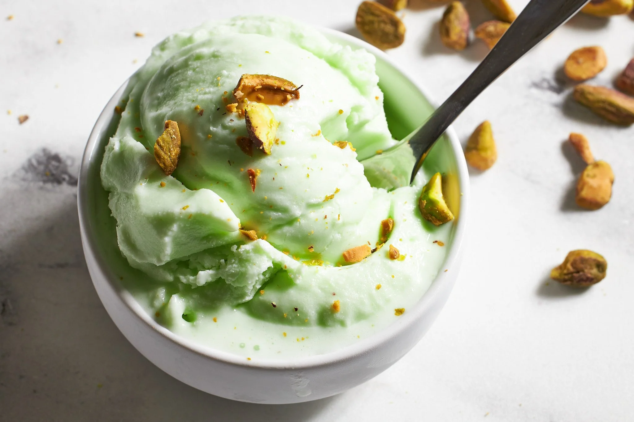 Ninja Creami Pistachio Ice Cream on neutral background with pistachios