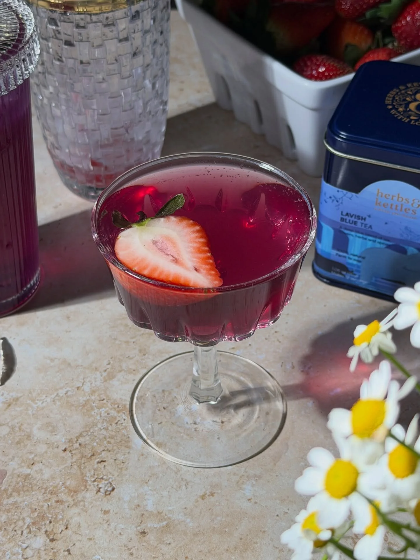 The prettiest little mocktail to invite spring 
2 oz @herbsandkettles Lavish Blue Tea
2 oz lemonade
1 tablespoon of strawberry syrup
Shake it together with lots of ice
Strain into a coupe glass
Top with sparkling water &amp; a strawberry slice
.
#moc