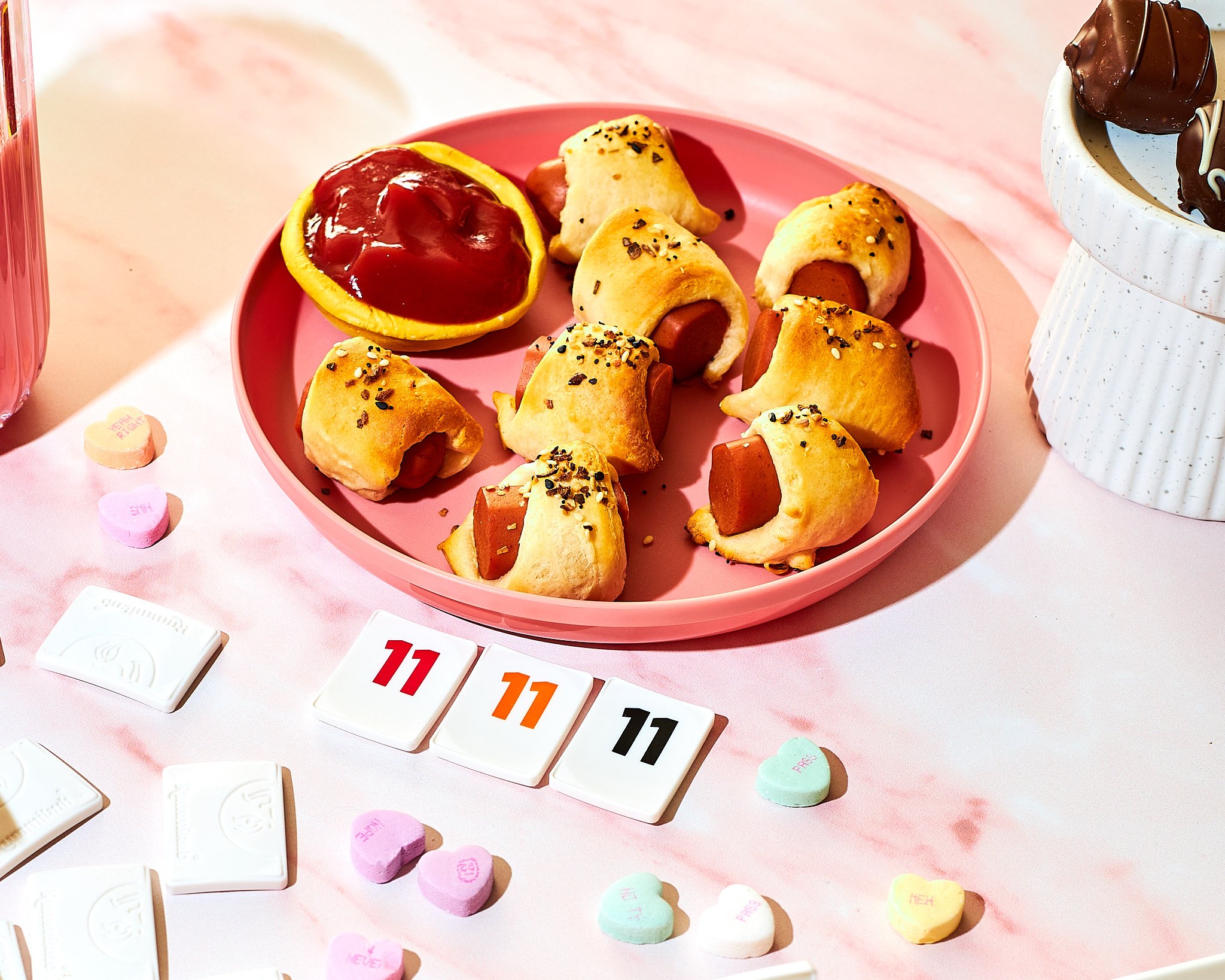 vegetarian hot dogs cut into one inch slices wrapped in crescent rolls with ketchup for dipping on the side in a yellow bowl