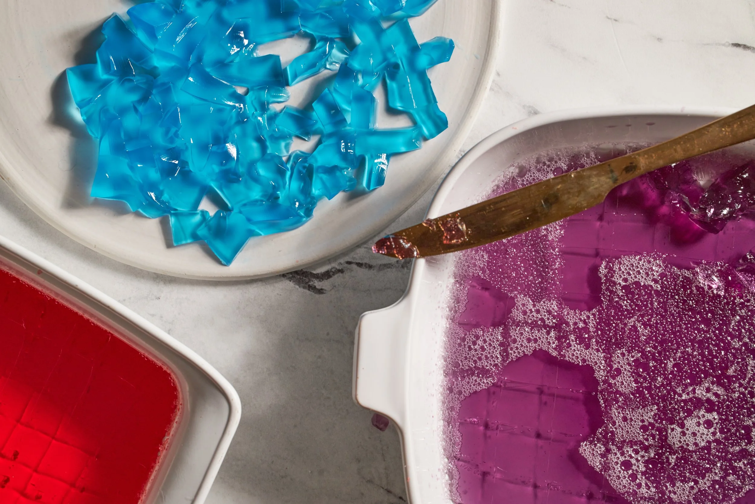 boxes of strawberry jello grape jello blue jello in baking dish for broken jello dessert jessica furniss