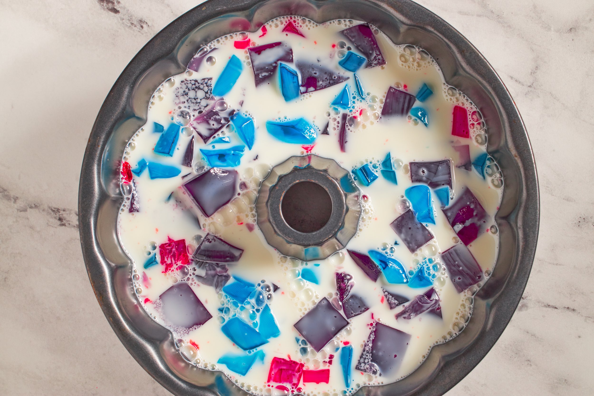 broken glass jello in bundt pan on a neutral background