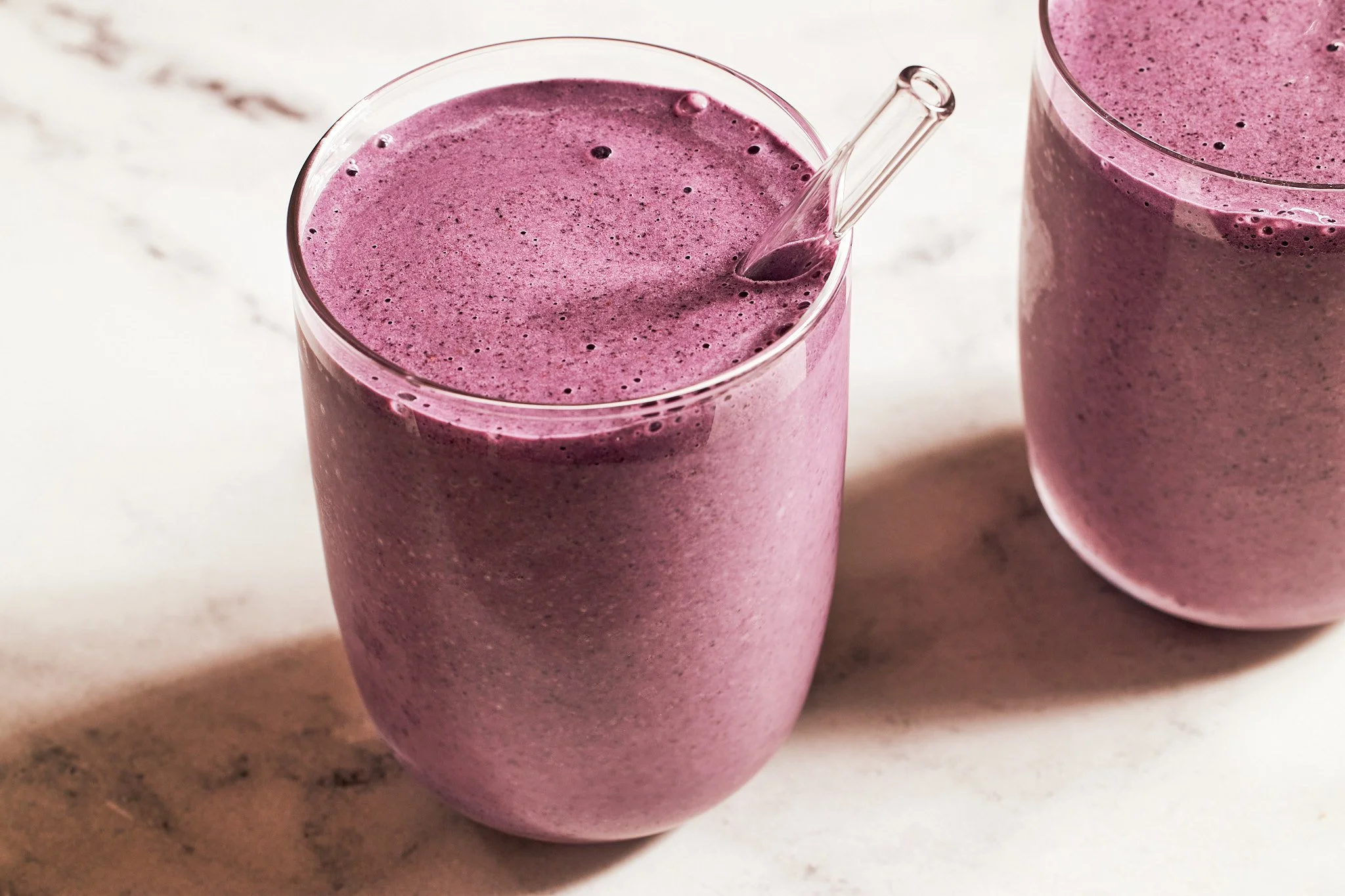 Blueberry smoothies in glass on a neutral surface