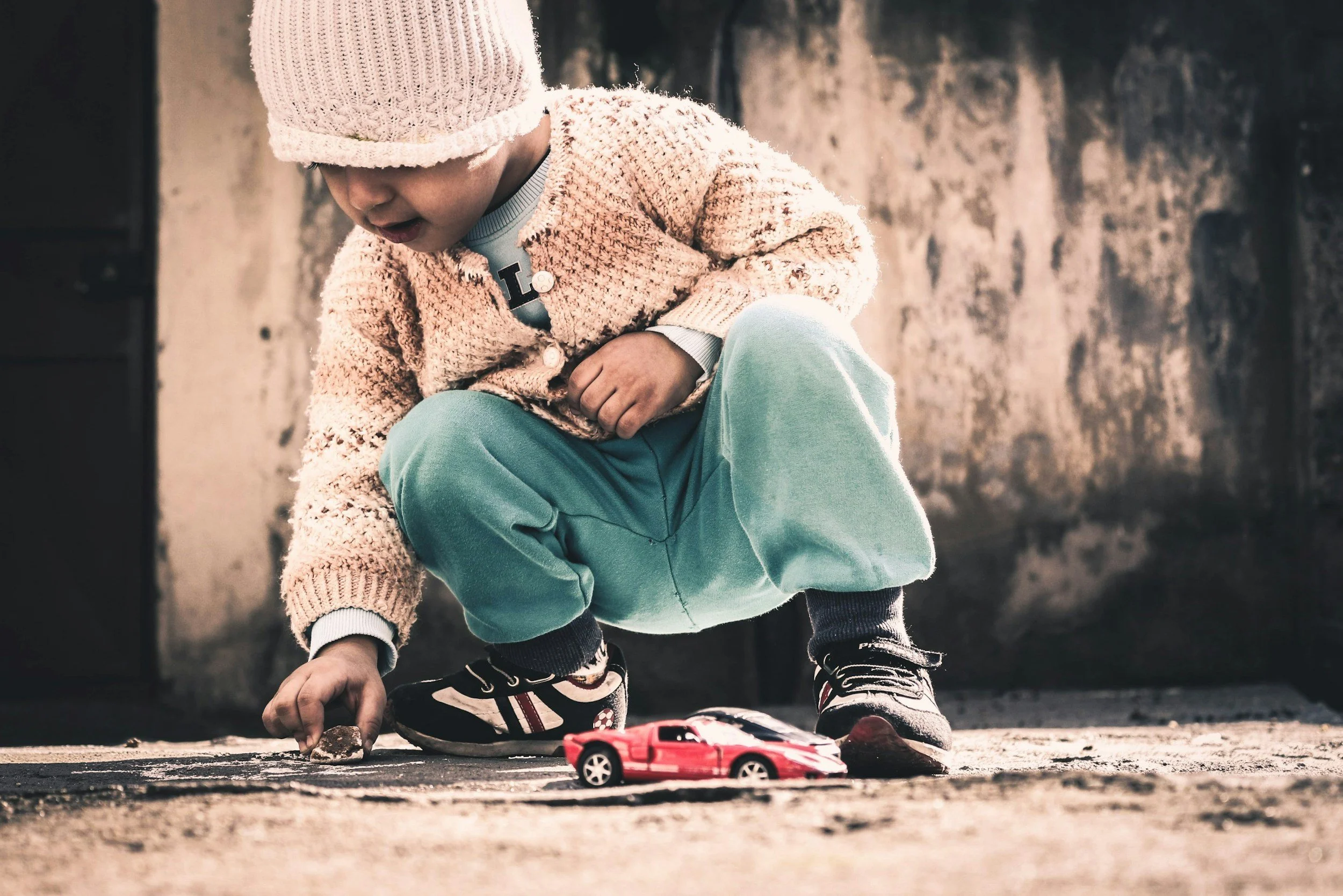 Child playing to with old painted toy.