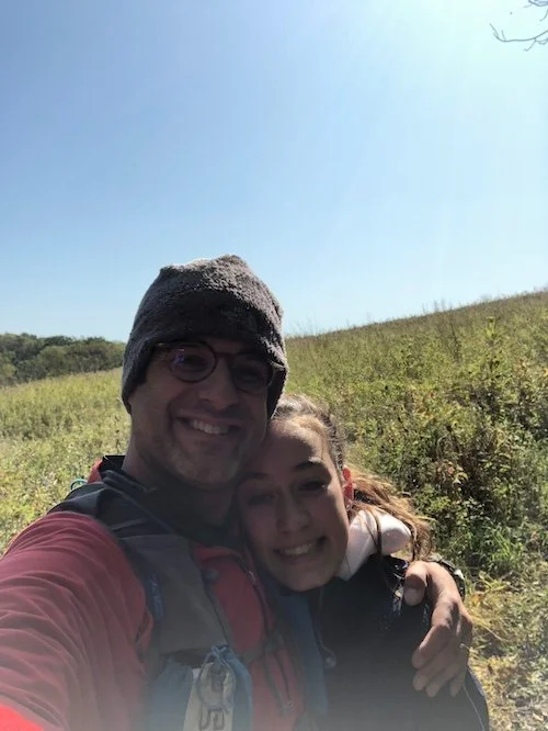 Dad and daughter stopping to take a picture on a singletrack trail.
