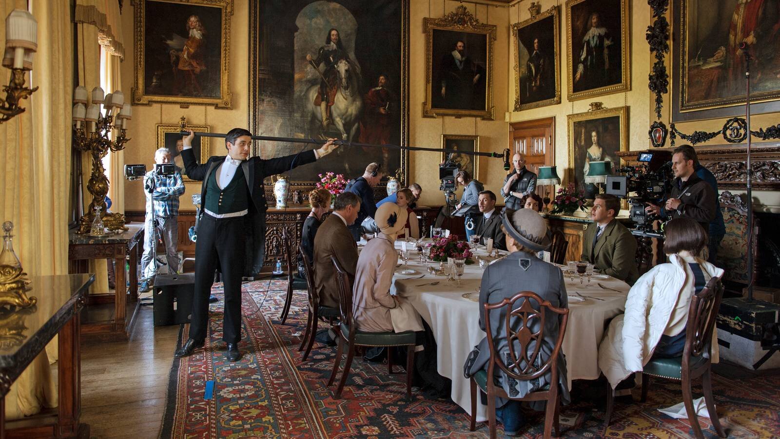 In this shot taken during the day it is clearer to see how the room looks. The soft yellow walls are covered in portraits which dominate the room whilst a mixture of heavy wood furniture also darkens the environment.
