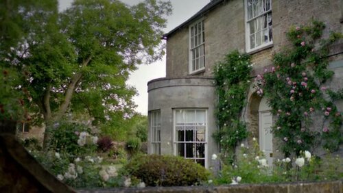 Although poor quality, this picture shows the Georgian charm of the house with its sash windows, simple facade and climbing roses. So English