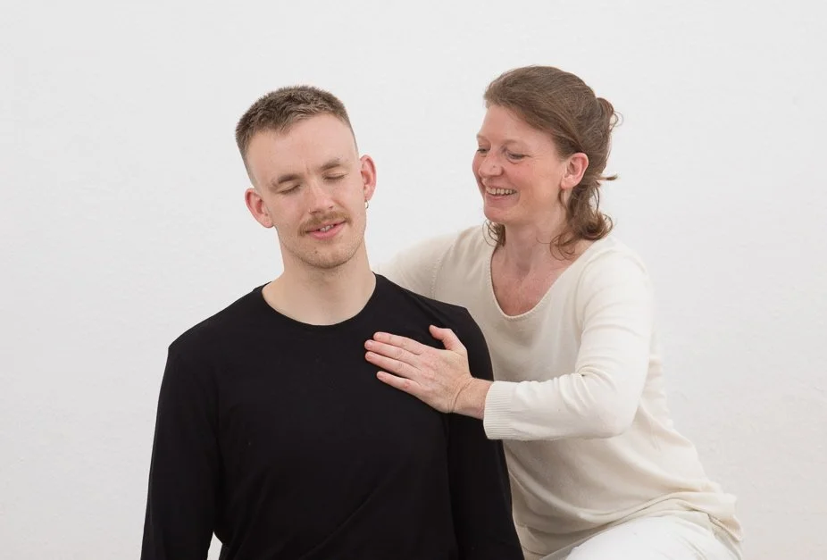 Barbara Naur bei einer Schulter-Behandlung in Sitzposition. Shiatsu im Sitzen erlaubt guten Zugang zum Kopf, Rücken und Schultern bei verkürzter Muskulatur im Brustbereich und Verspannungen im Nacken.