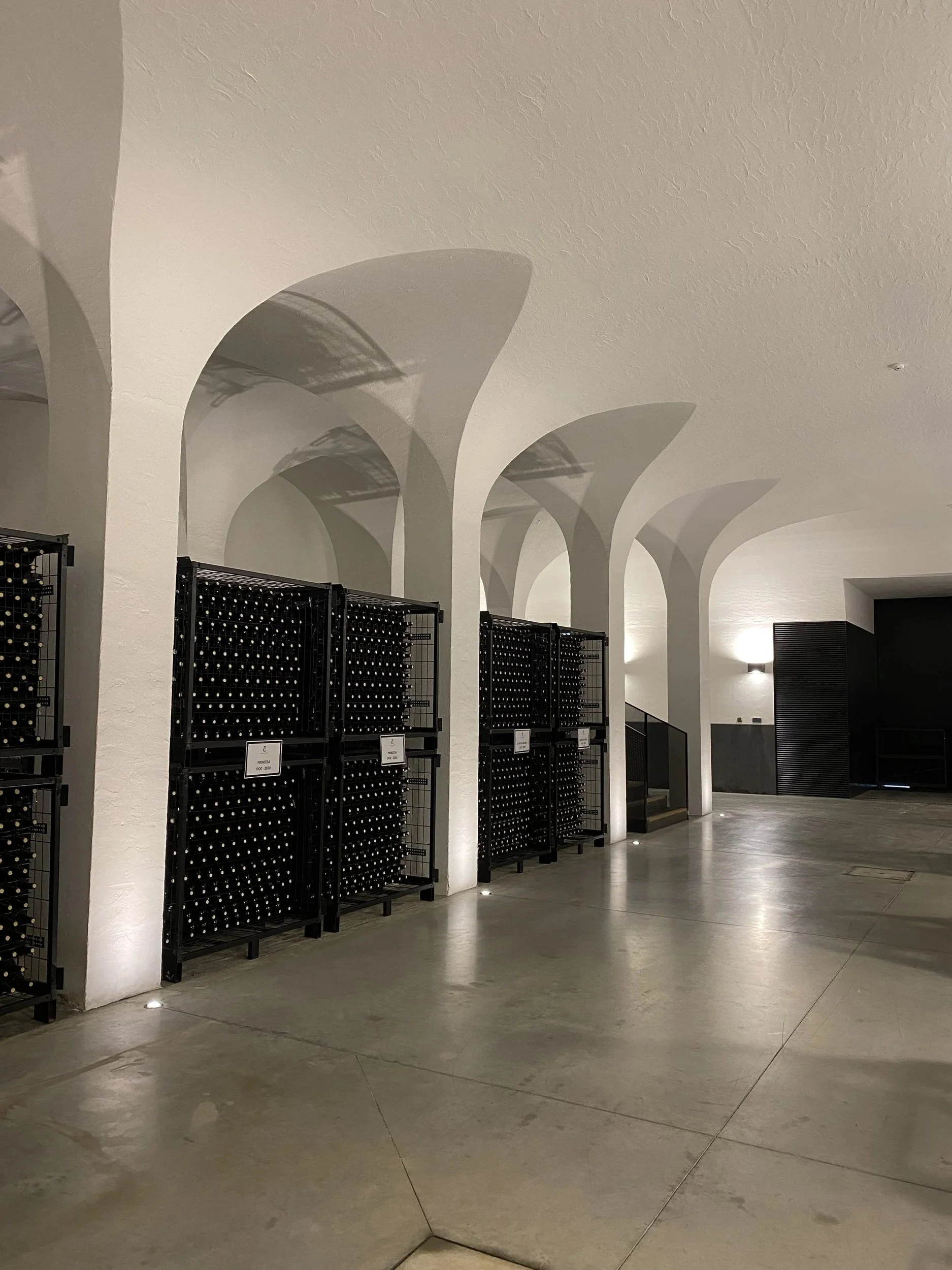 Bottles resting under the white vaulted arches of the cellar at Quinta da Côrte.