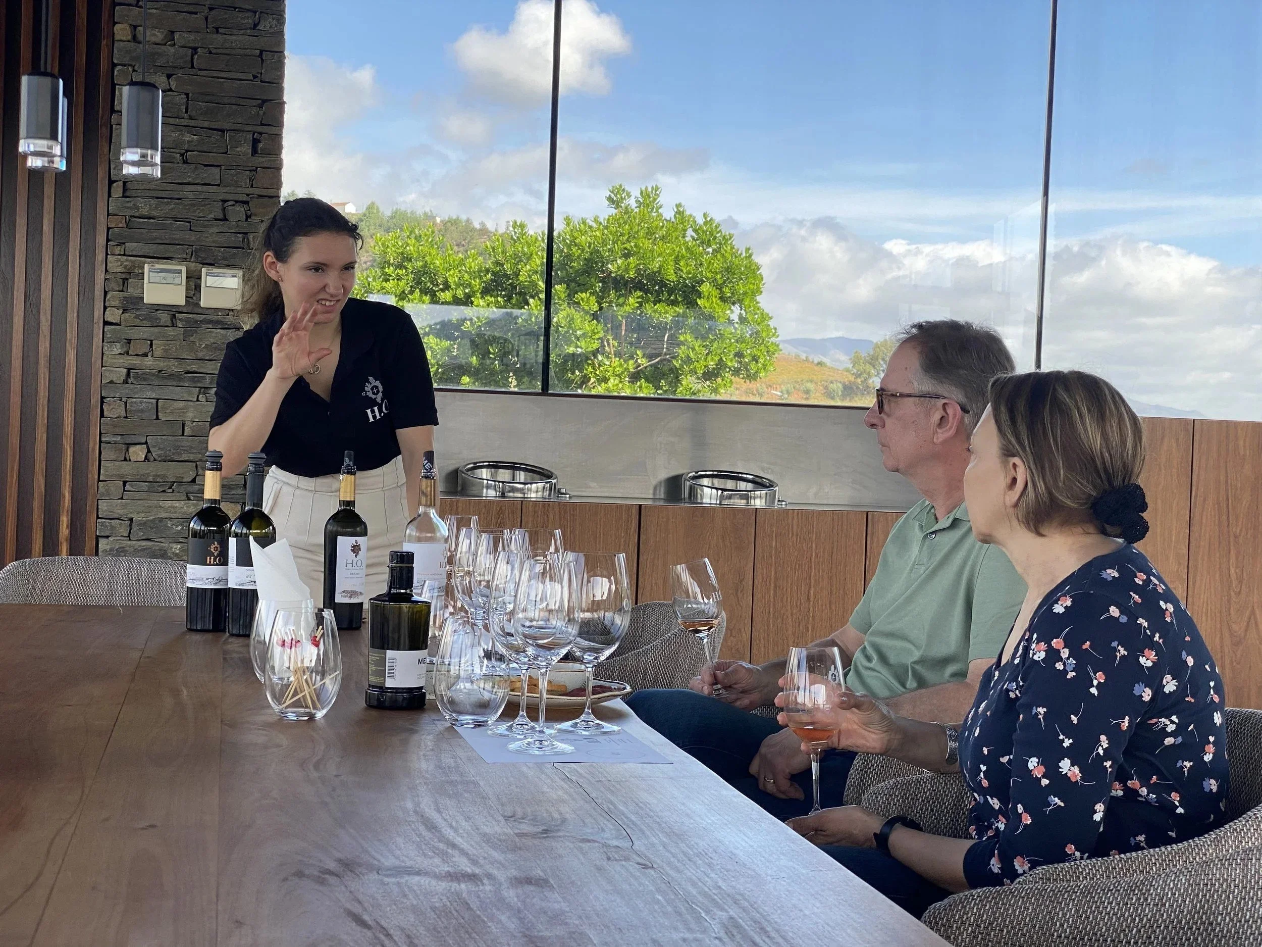 A host pouring a tasting for two guests at a Douro winery.
