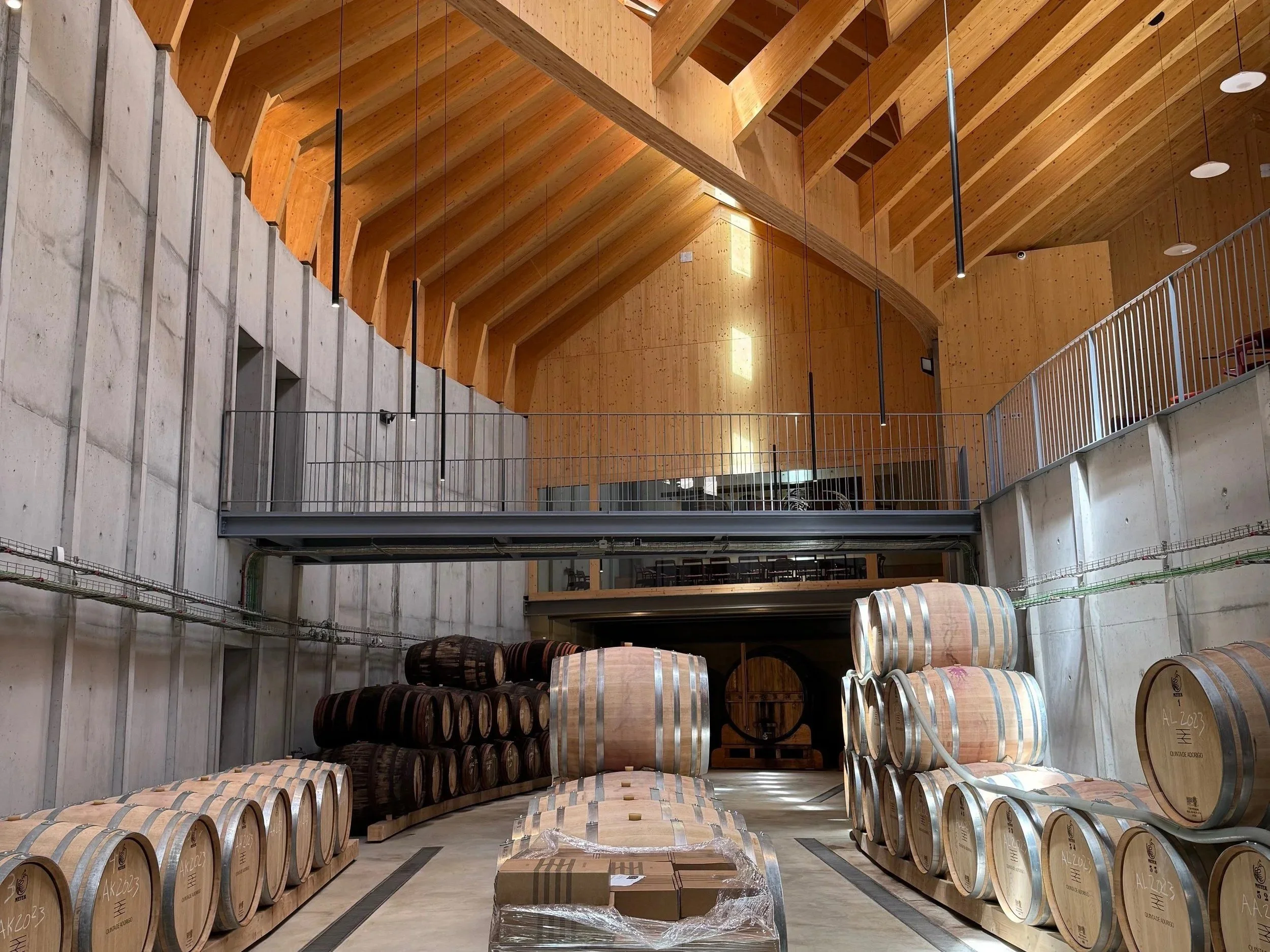 Oak barrels under the timber roof of the Adorigo winery.