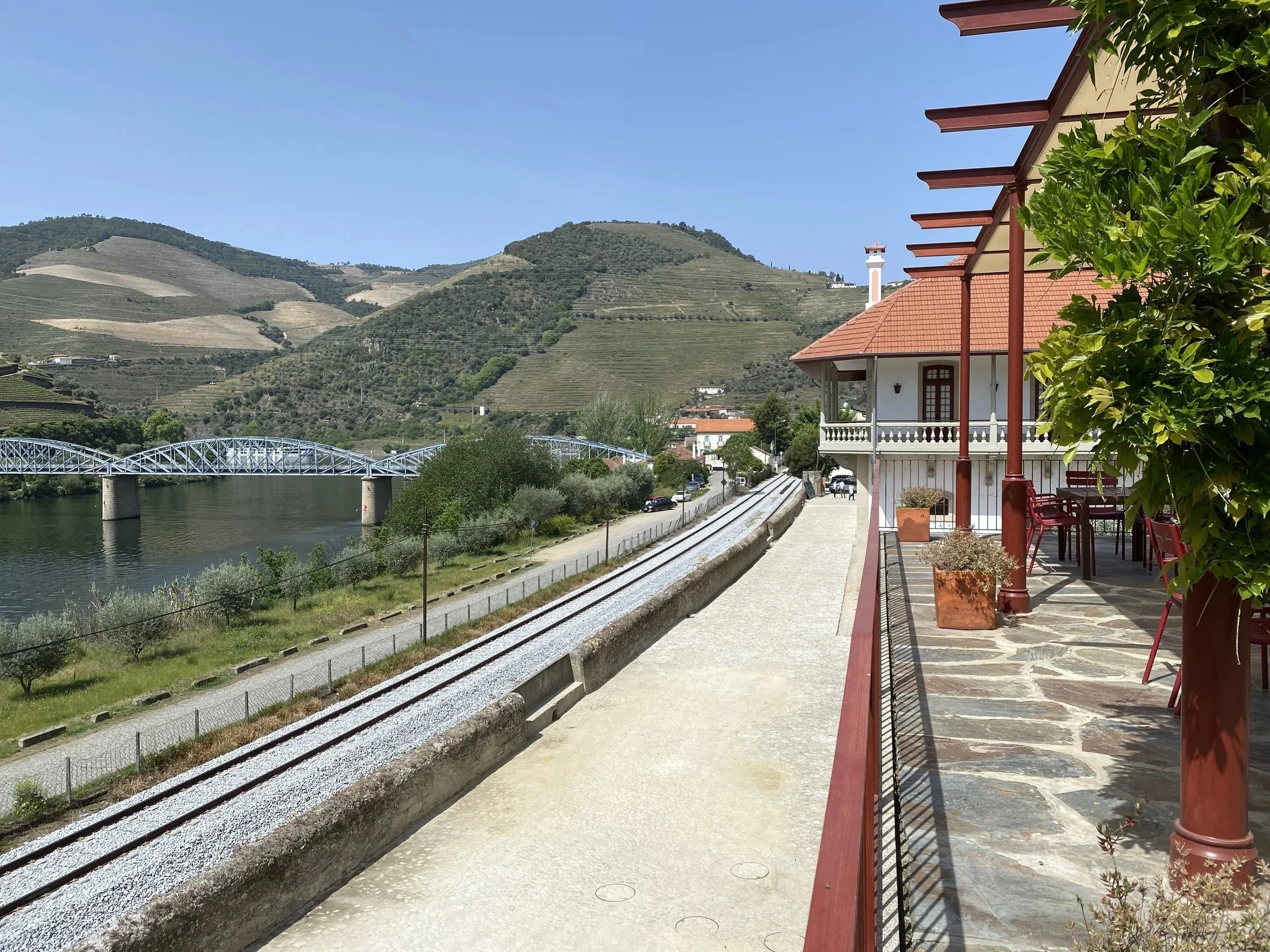 The terrace at Quinta do Bomfim, with the Pinhão railway bridge and terraced hills behind.