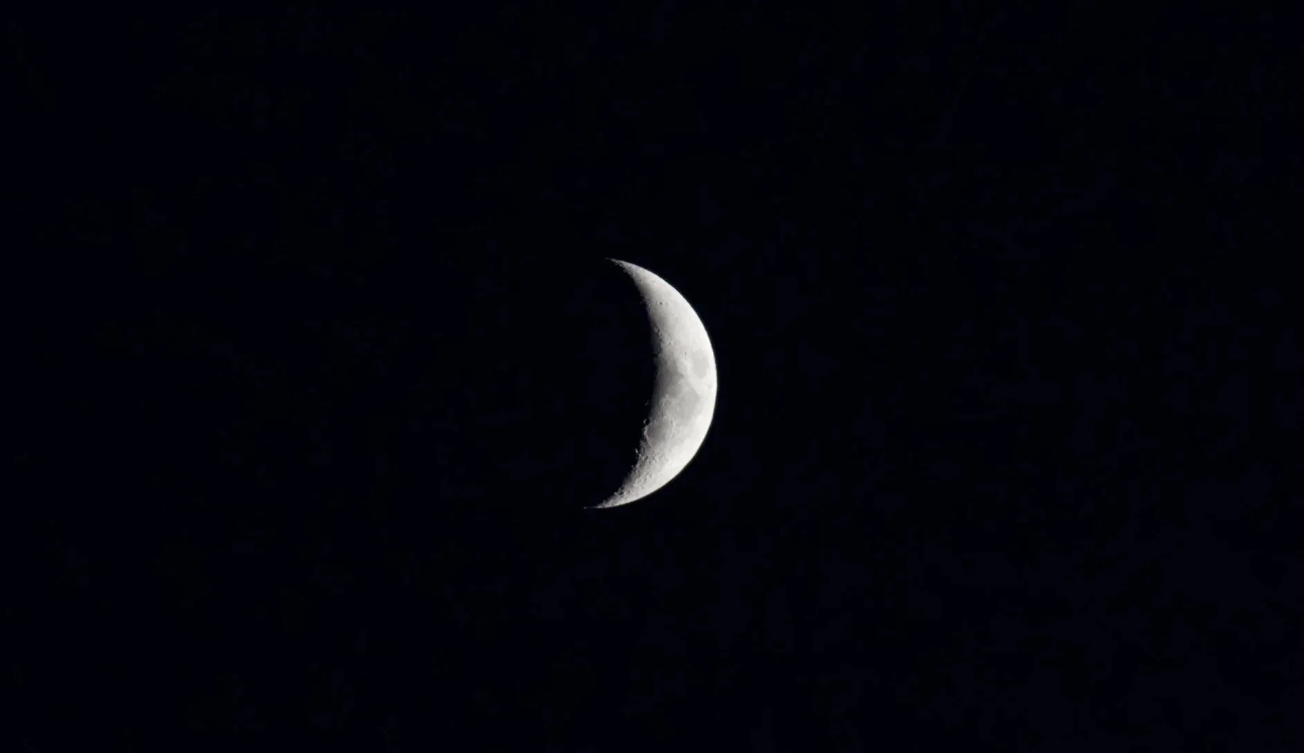 A crescent moon in the dark sky above the Douro Valley.