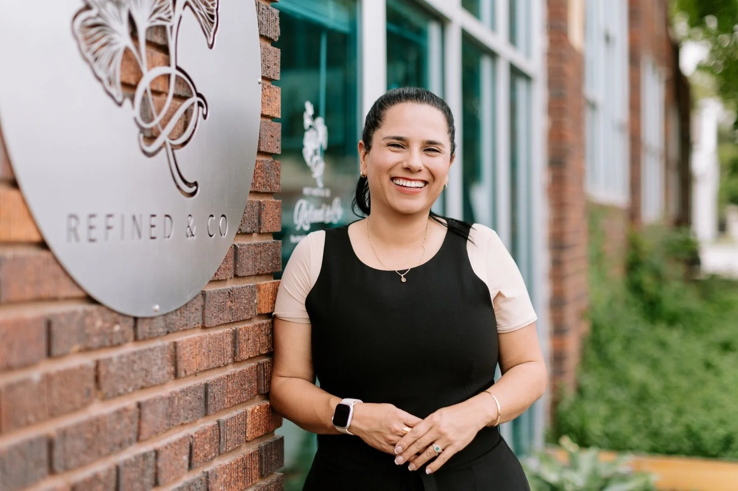 Photo of Marcela Willeke standing next to the Refined & Co boutique sign