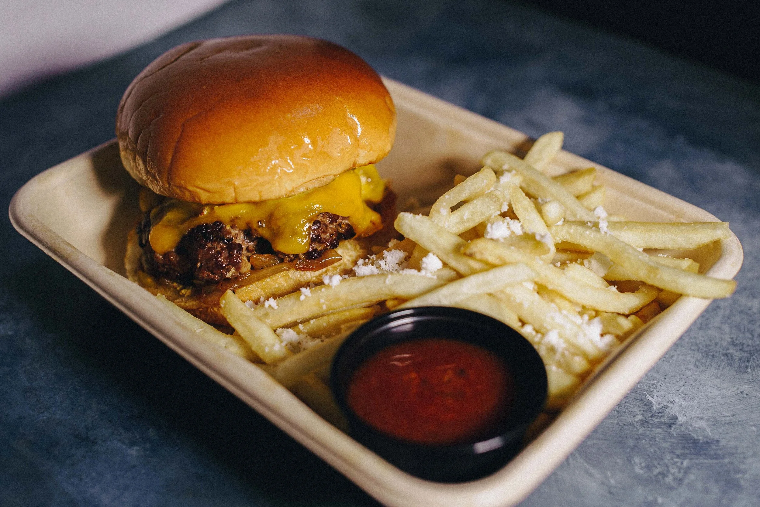 Cheeseburger with fries in a tray