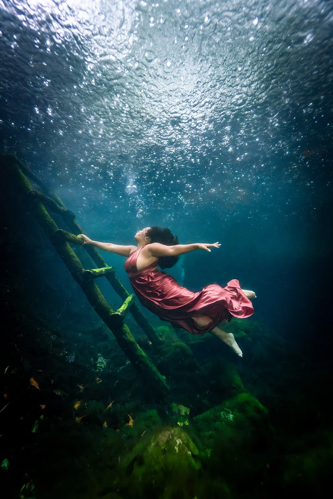 An African American woman posing for an underwater photoshoot in Playa del Carmen