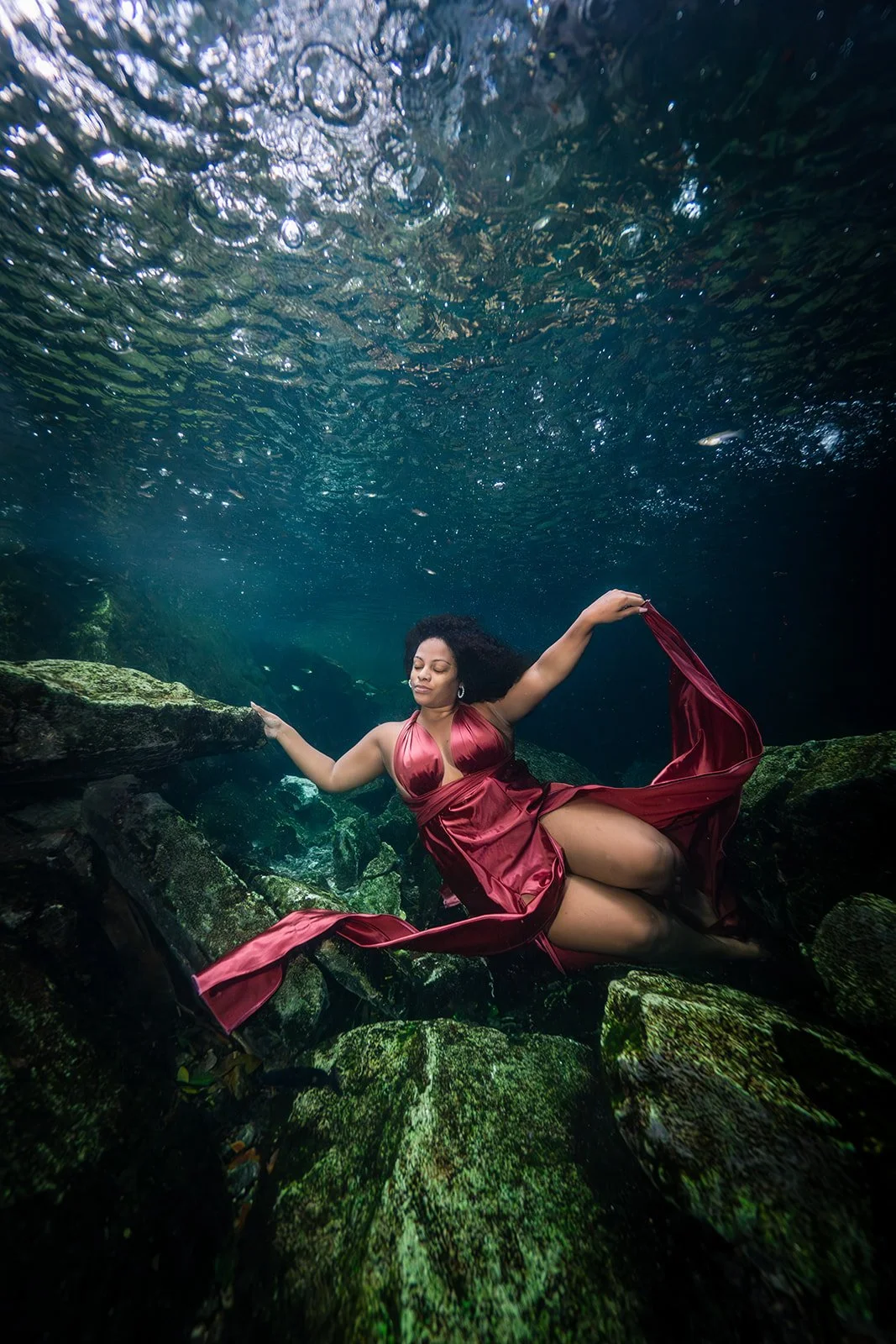 An African American woman posing for an underwater photoshoot